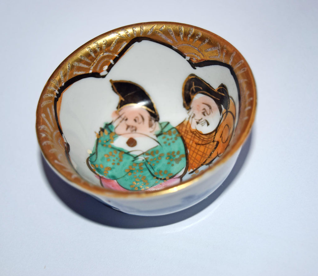 Decorative ceramic bowl with artistic depiction of two figures on a white background