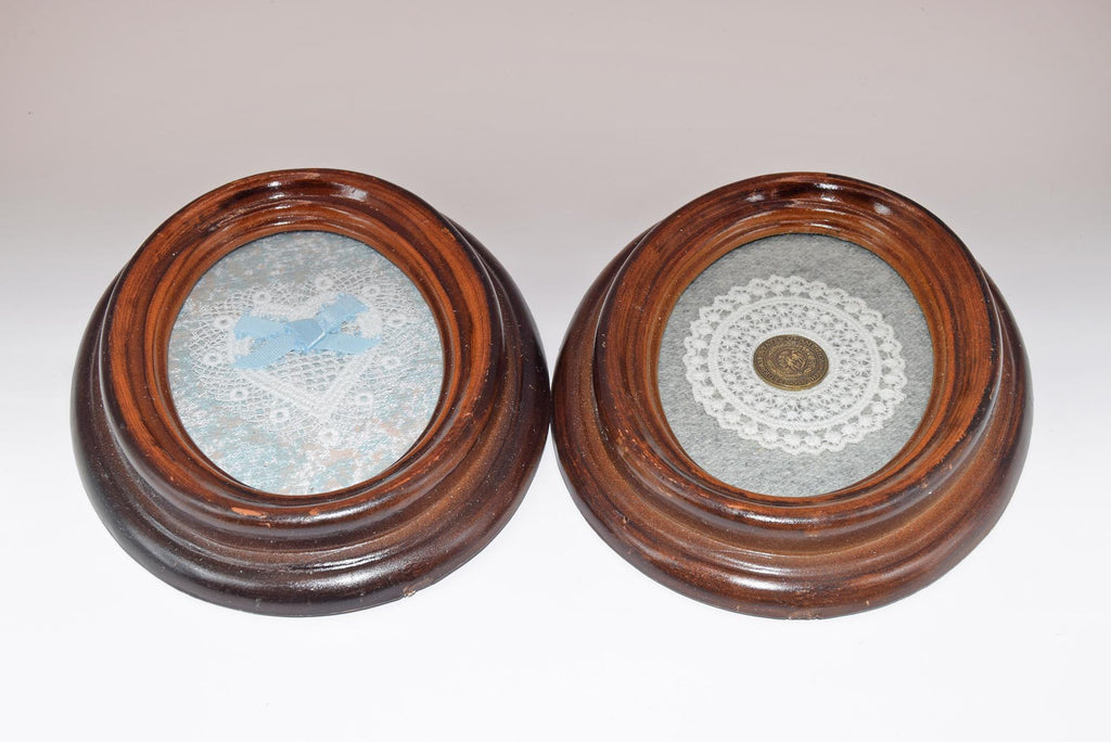 Two round wooden frames with decorative contents on a light gray background