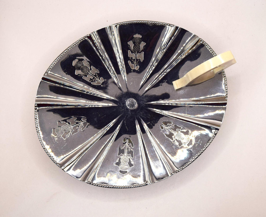 Decorative silver plate with engraved designs on a white background