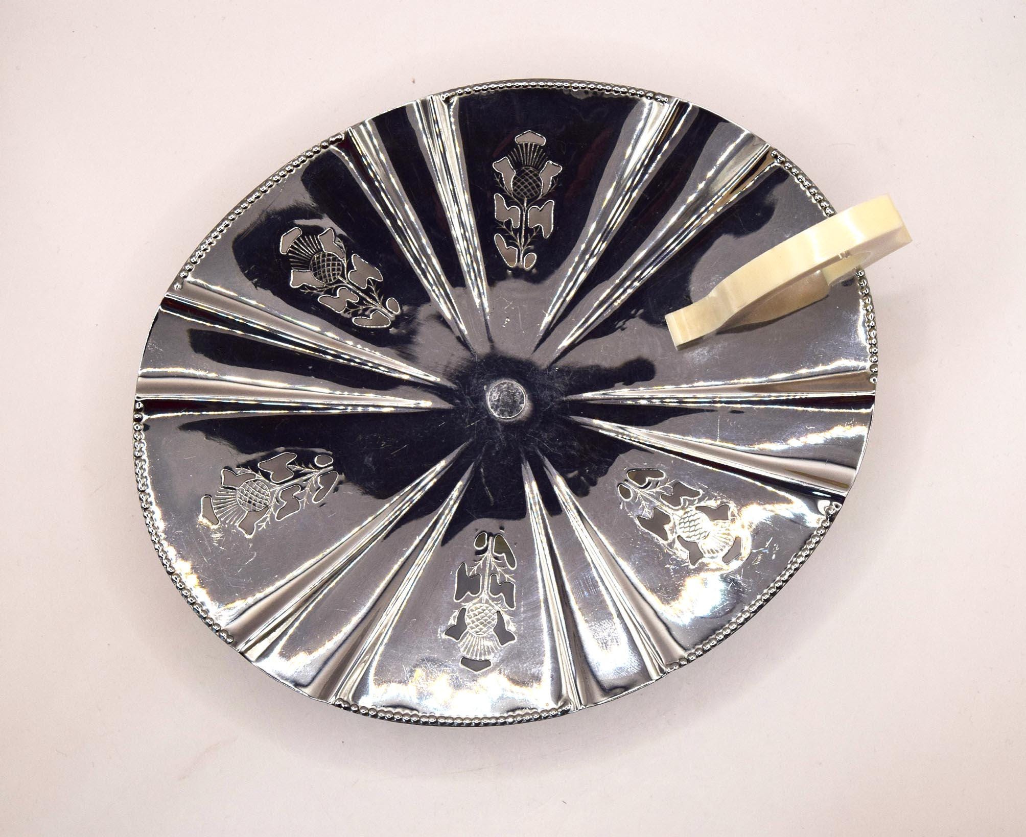 Decorative silver plate with engraved designs on a white background