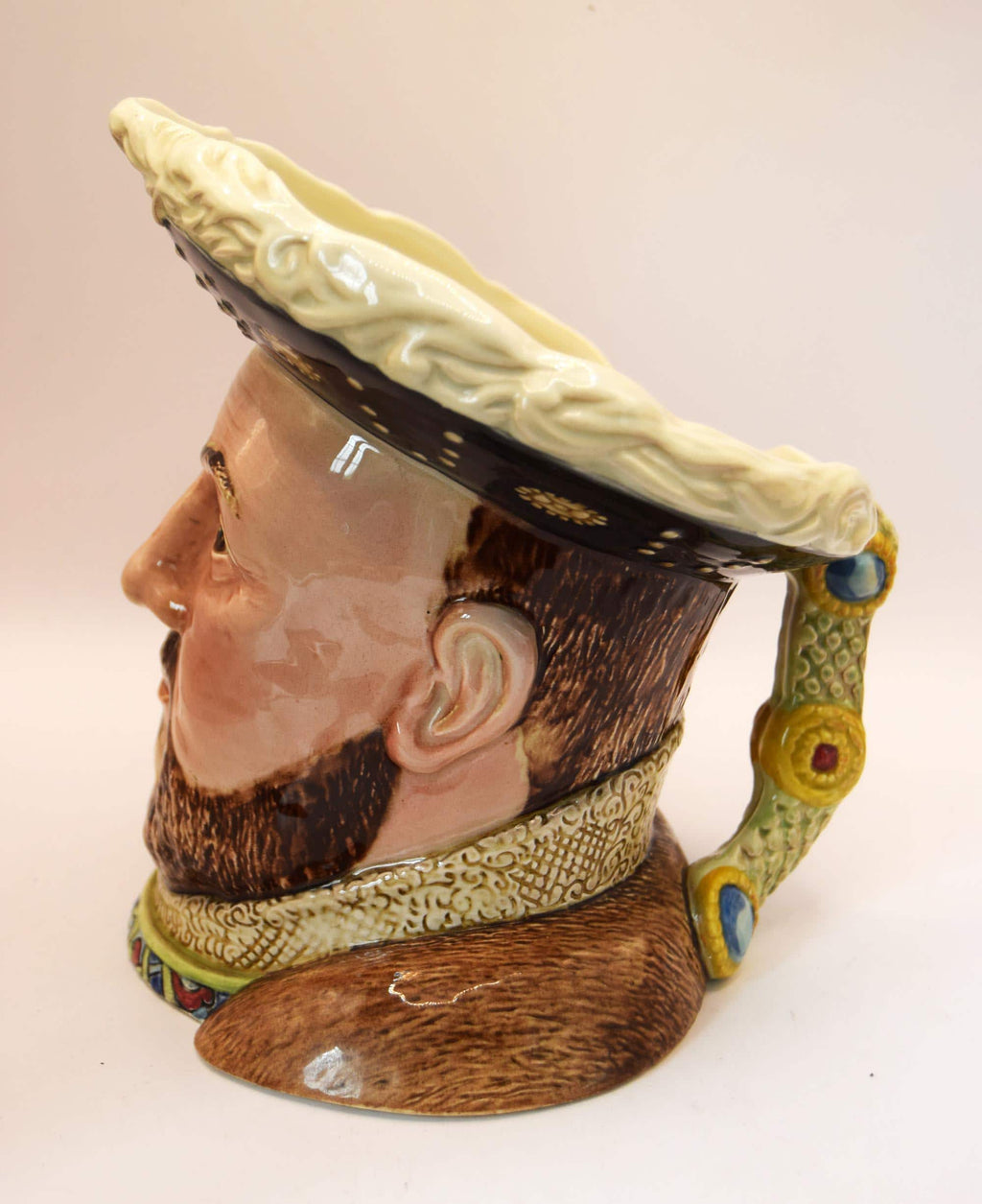 Ceramic figure of a man's head with a large hat on a white background