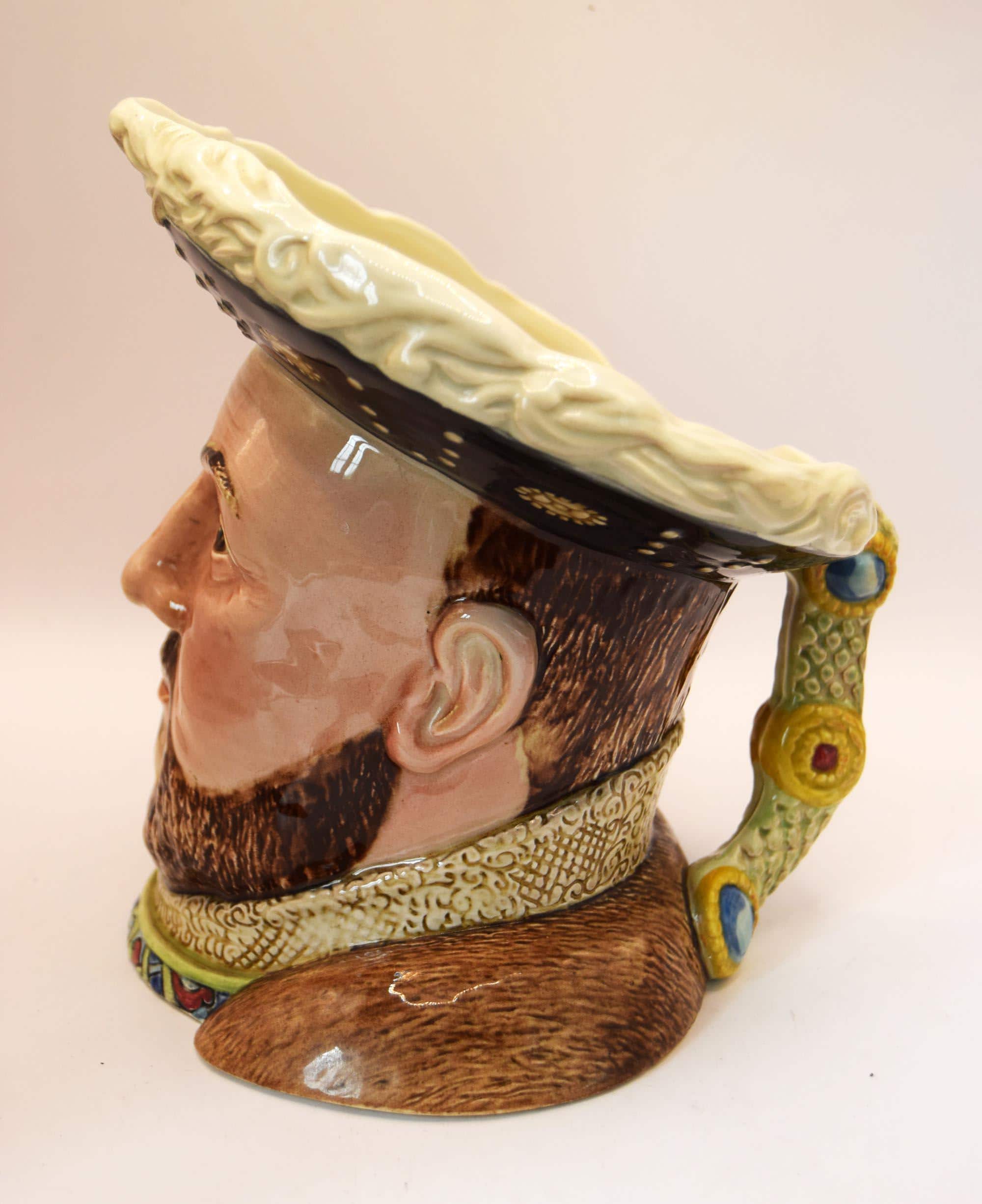 Ceramic figure of a man's head with a large hat on a white background