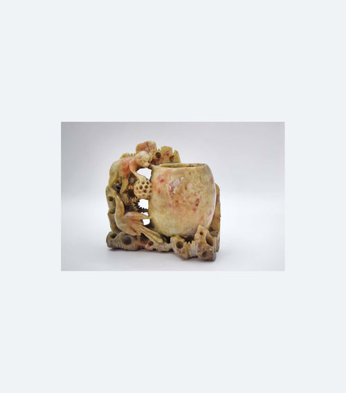 Decorative soapstone Chinese brush pot or vase with a naturalistic design on a white background