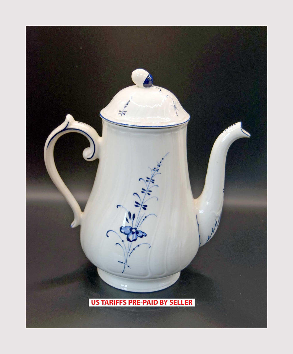 White teapot with blue floral patterns on a dark background