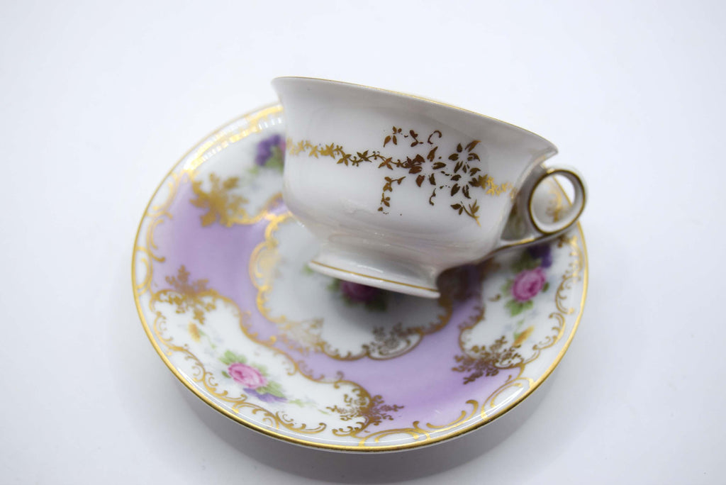Porcelain teacup and saucer with floral patterns on a white background
