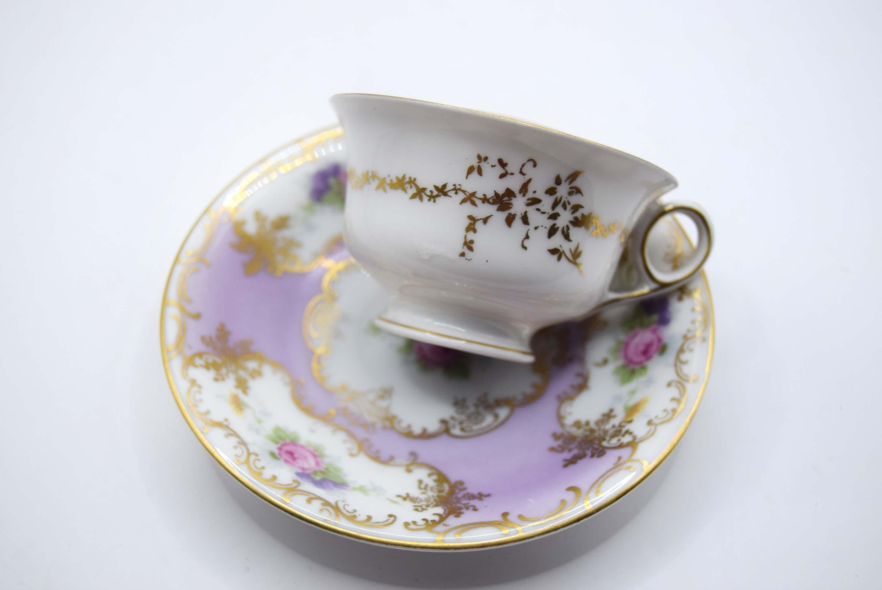 Porcelain teacup and saucer with floral patterns on a white background