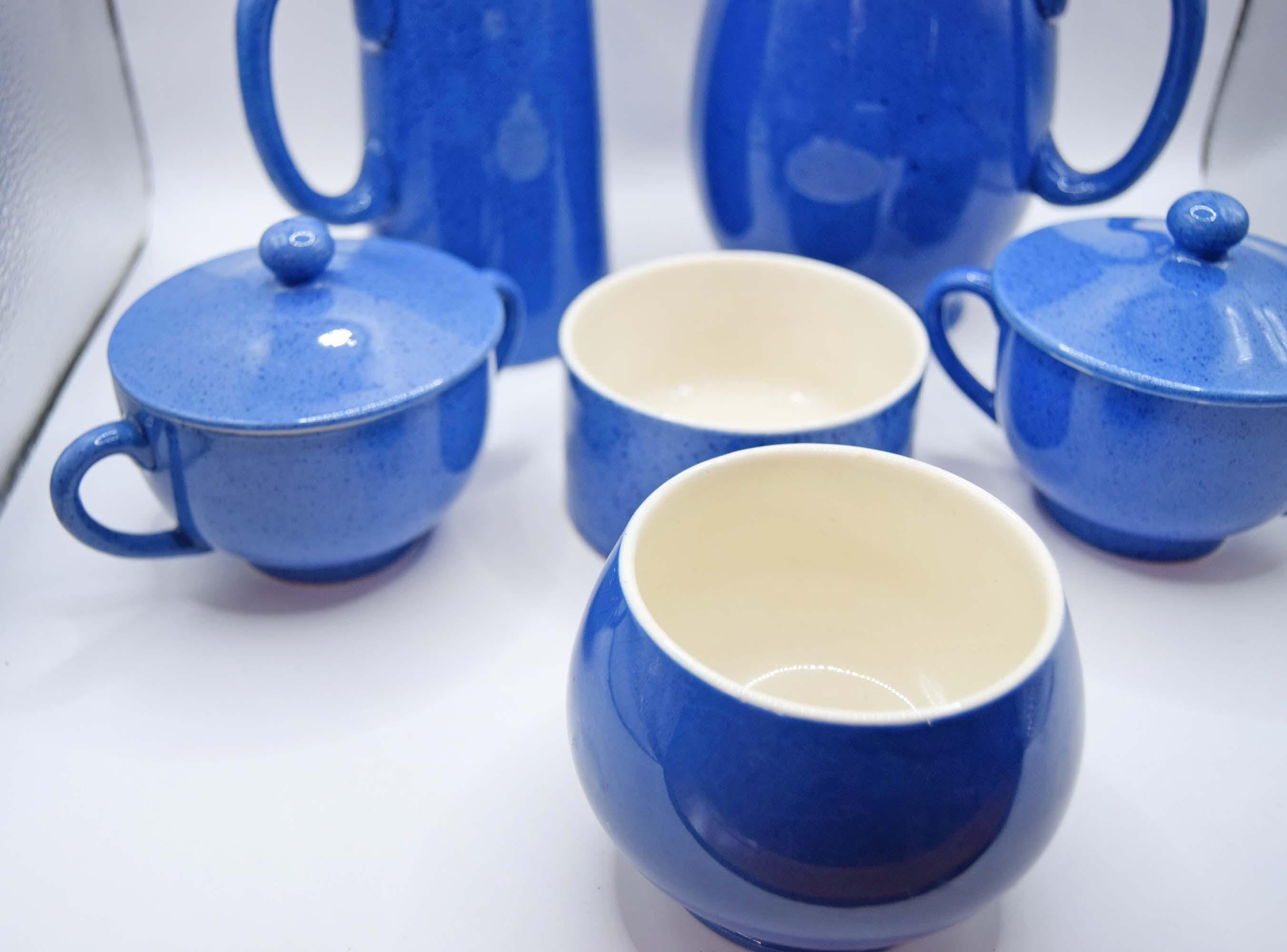 Set of blue ceramic mugs with white interiors on a white background