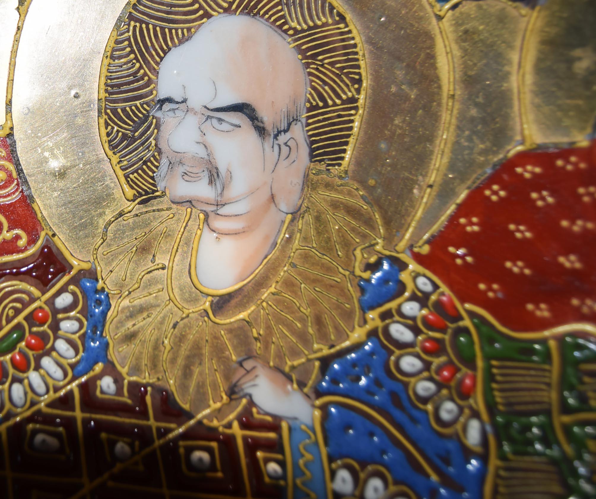  heavy quality, antique Japanese plate features an intricate hand-painted scene of three immortals against a rich landscape backdrop, adorned with lavish gold detailing. 