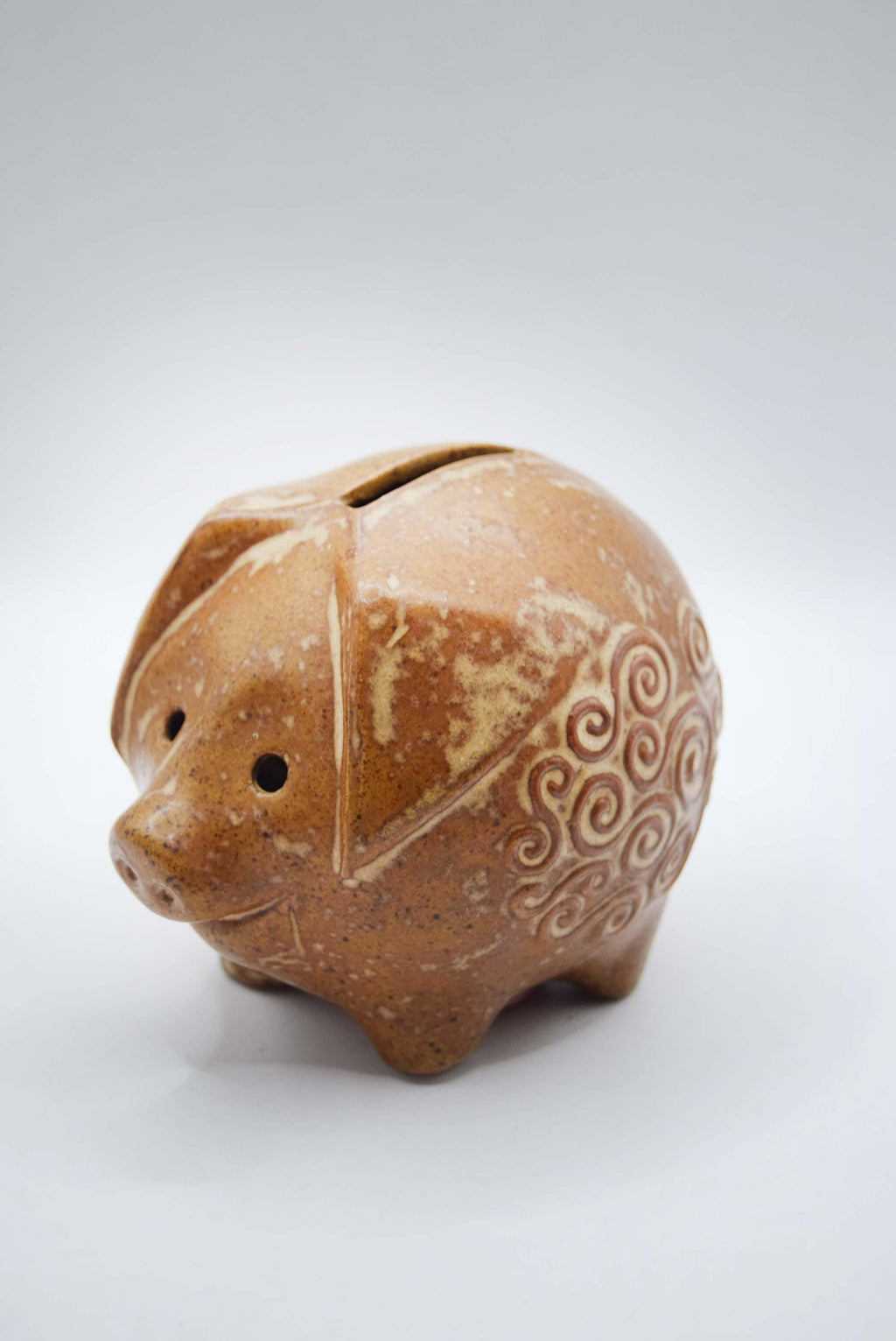 Ceramic piggy bank with decorative patterns on a white background