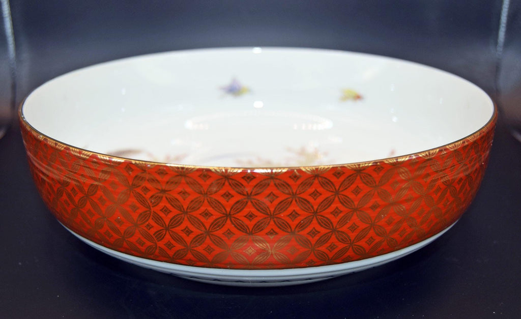 Decorative bowl with red geometric pattern on a dark background