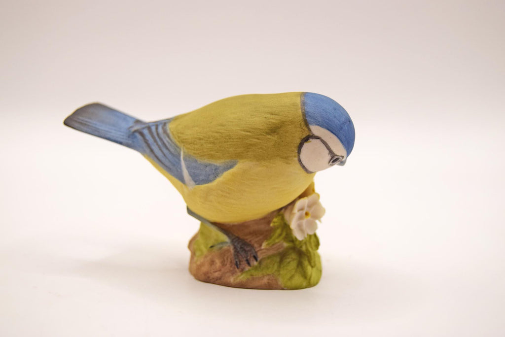 Bird figurine with blue and yellow colors on a white background