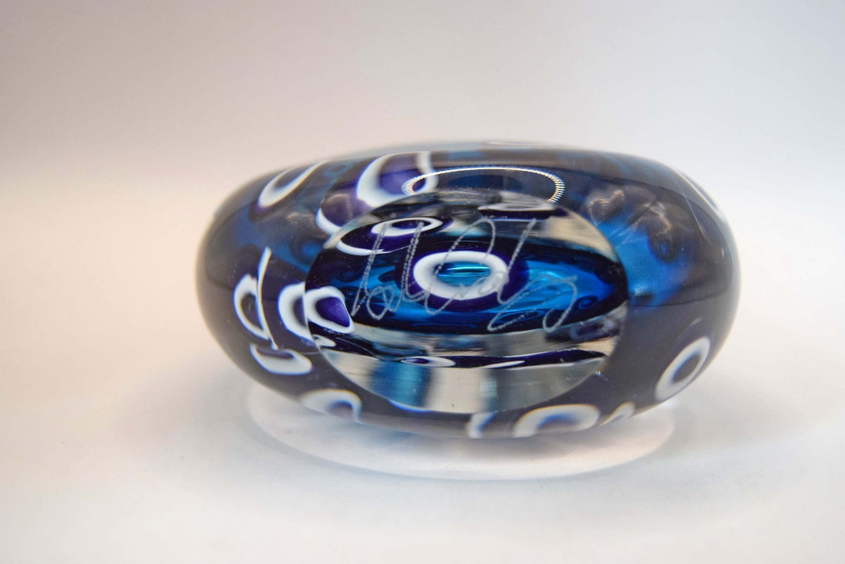  heavy-weight perfume/scent bottle is individually handblown by the highly recognized master glassmaker Bob Crooks at his independent studio.
Part of his sought-after "Hula" series, the piece features a beautifully balanced teardrop/ovoid form. The body displays a vibrant palette of deep cobalt and electric blue tones accented by intricate, mosaic-like aubergine and white murrine inclusions. 