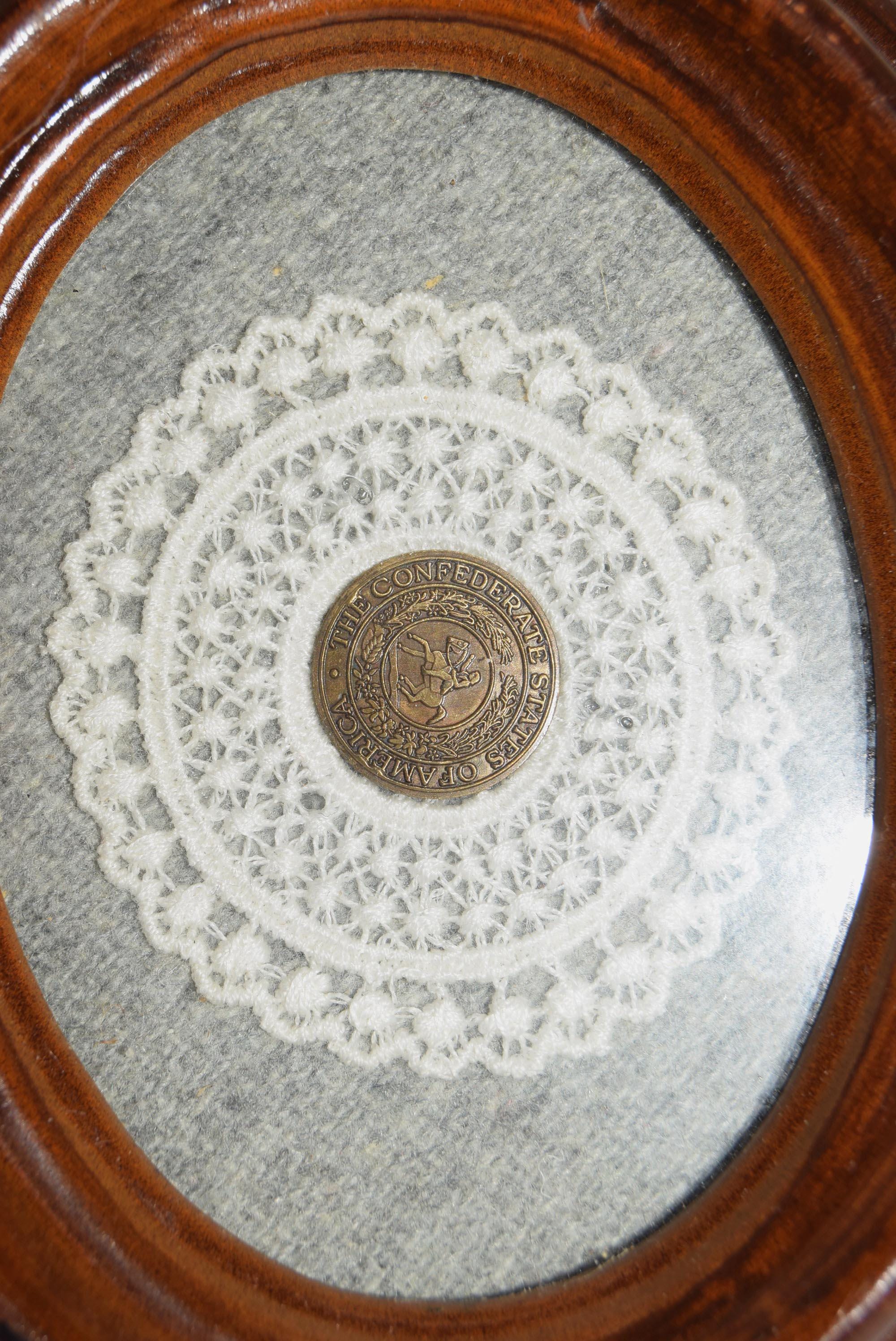 Medal on a lace doily inside an oval wooden frame