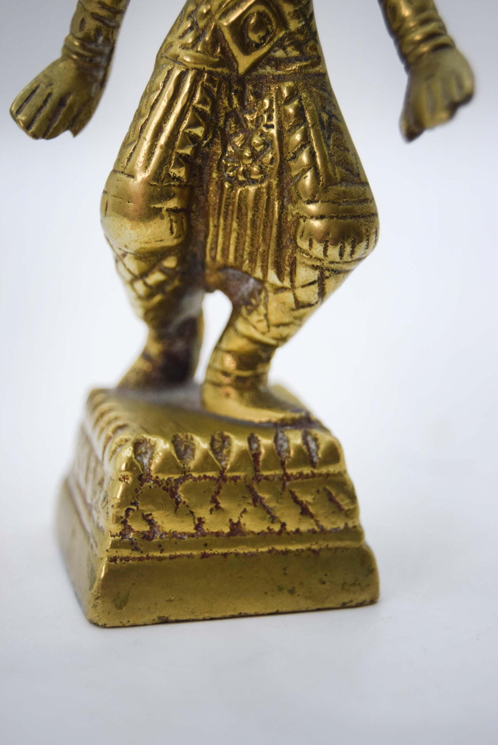 Close-up of a gold figurine on a white background