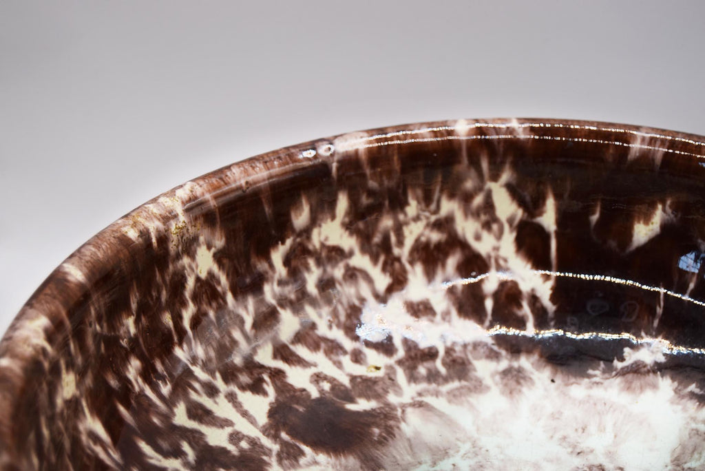 Marbled brown and white ceramic bowl on a gray background