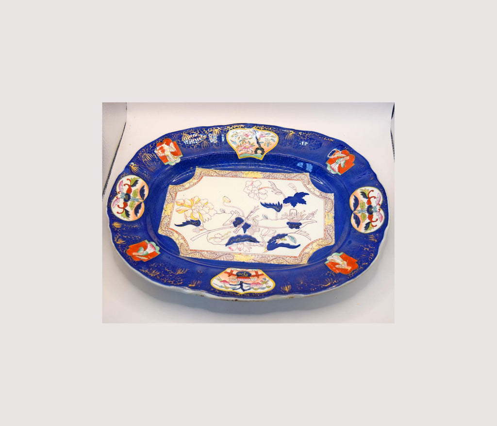 Decorative ceramic platter with blue border and colorful central design on a white background
