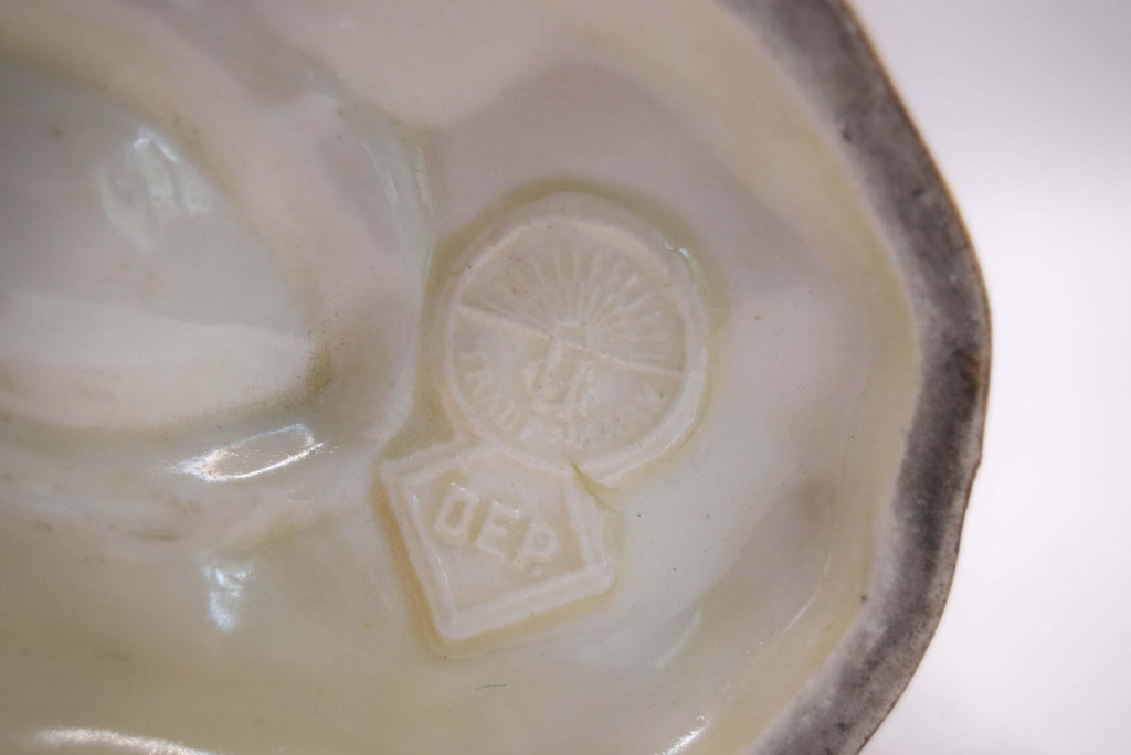 Close-up of a ceramic dish with a logo on a white background