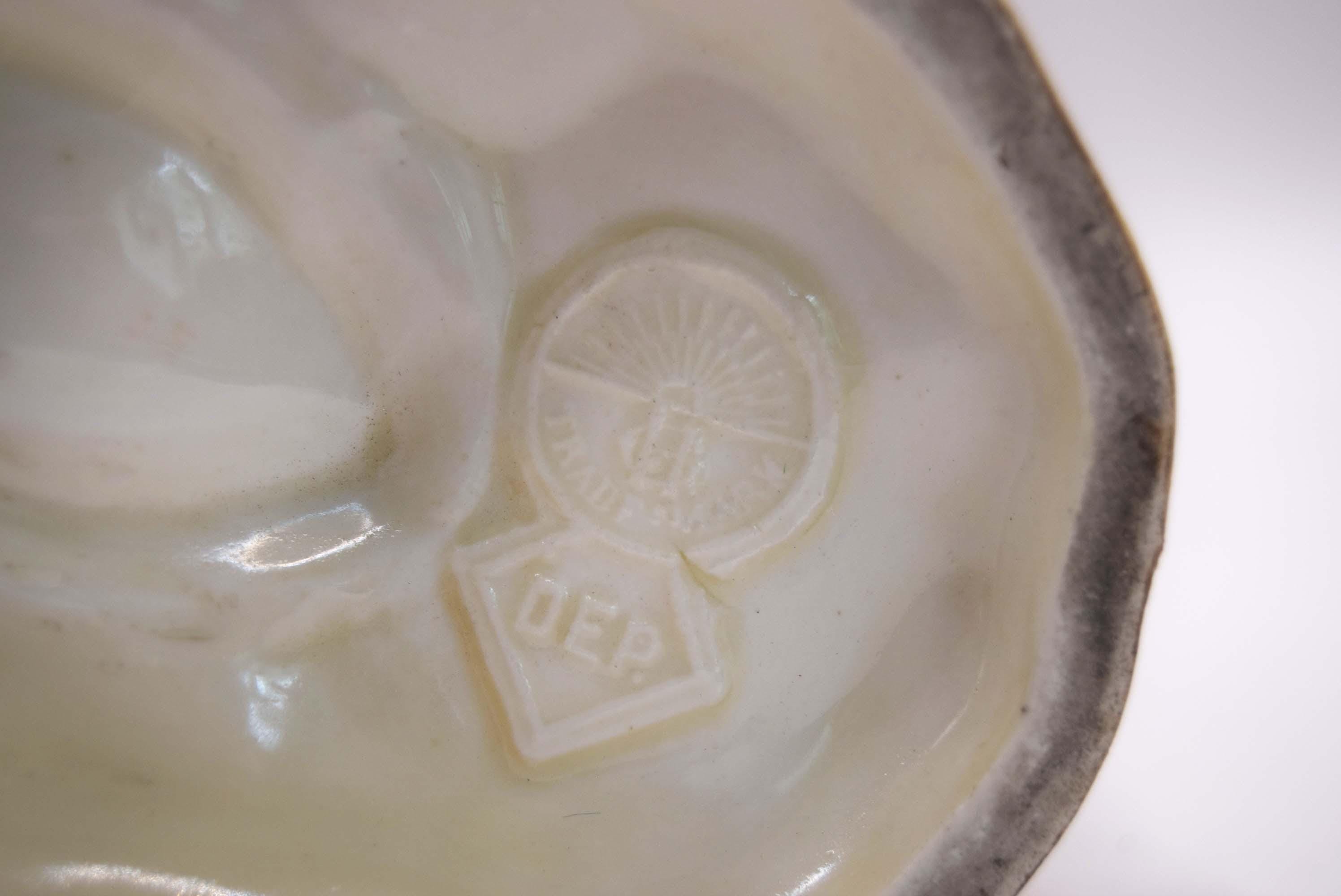 Close-up of a ceramic dish with a logo on a white background