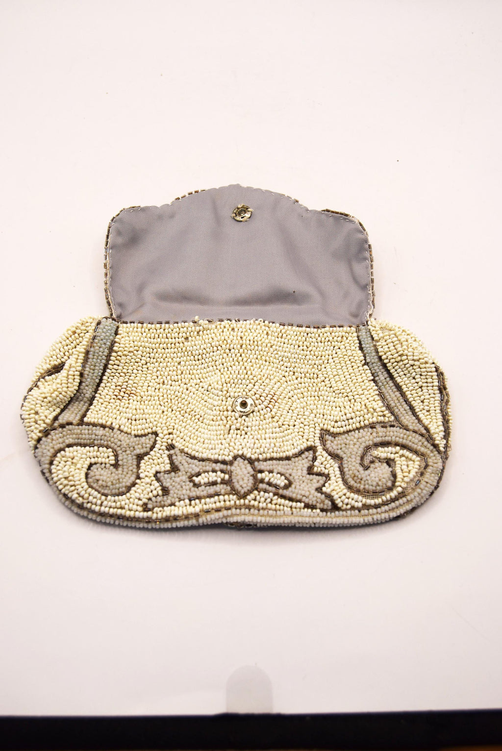 Beaded clutch bag with decorative bow on a white background