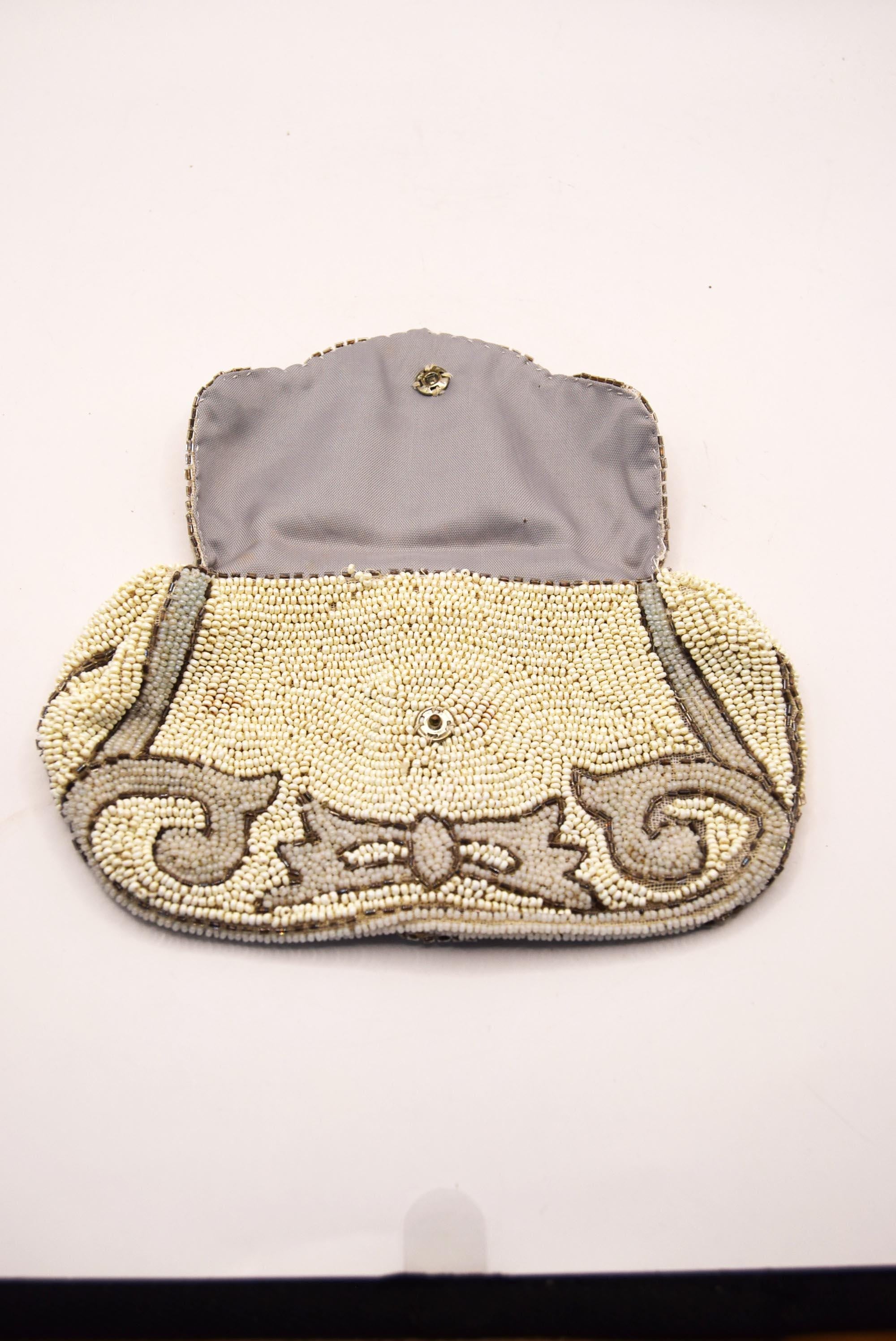 Beaded clutch bag with decorative bow on a white background