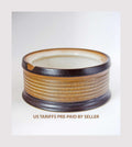 Ceramic bowl with brown and beige stripes on a white background