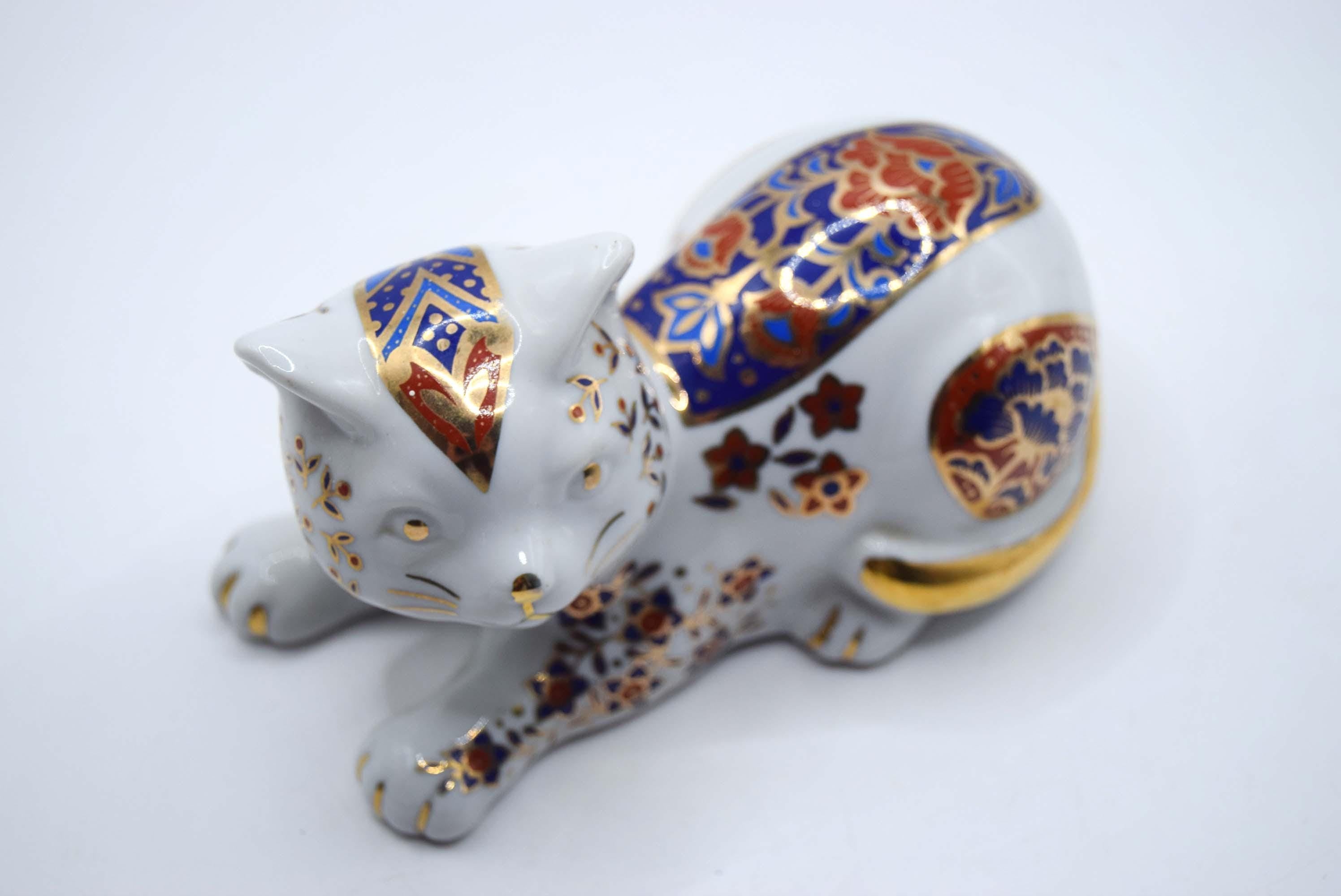 Decorative ceramic cat figurine with intricate patterns on a white background