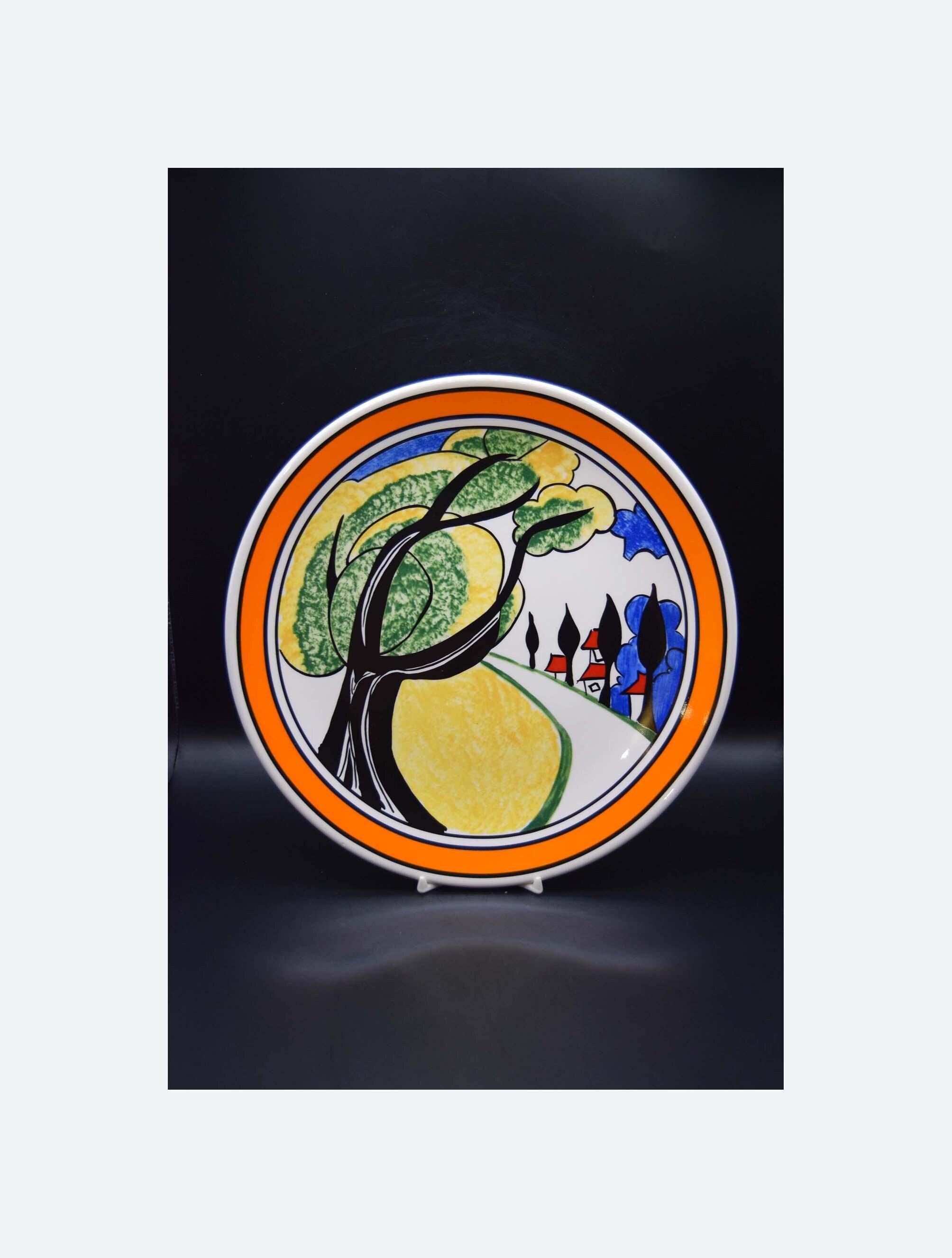 Decorative plate with artistic design of trees and people on a black background