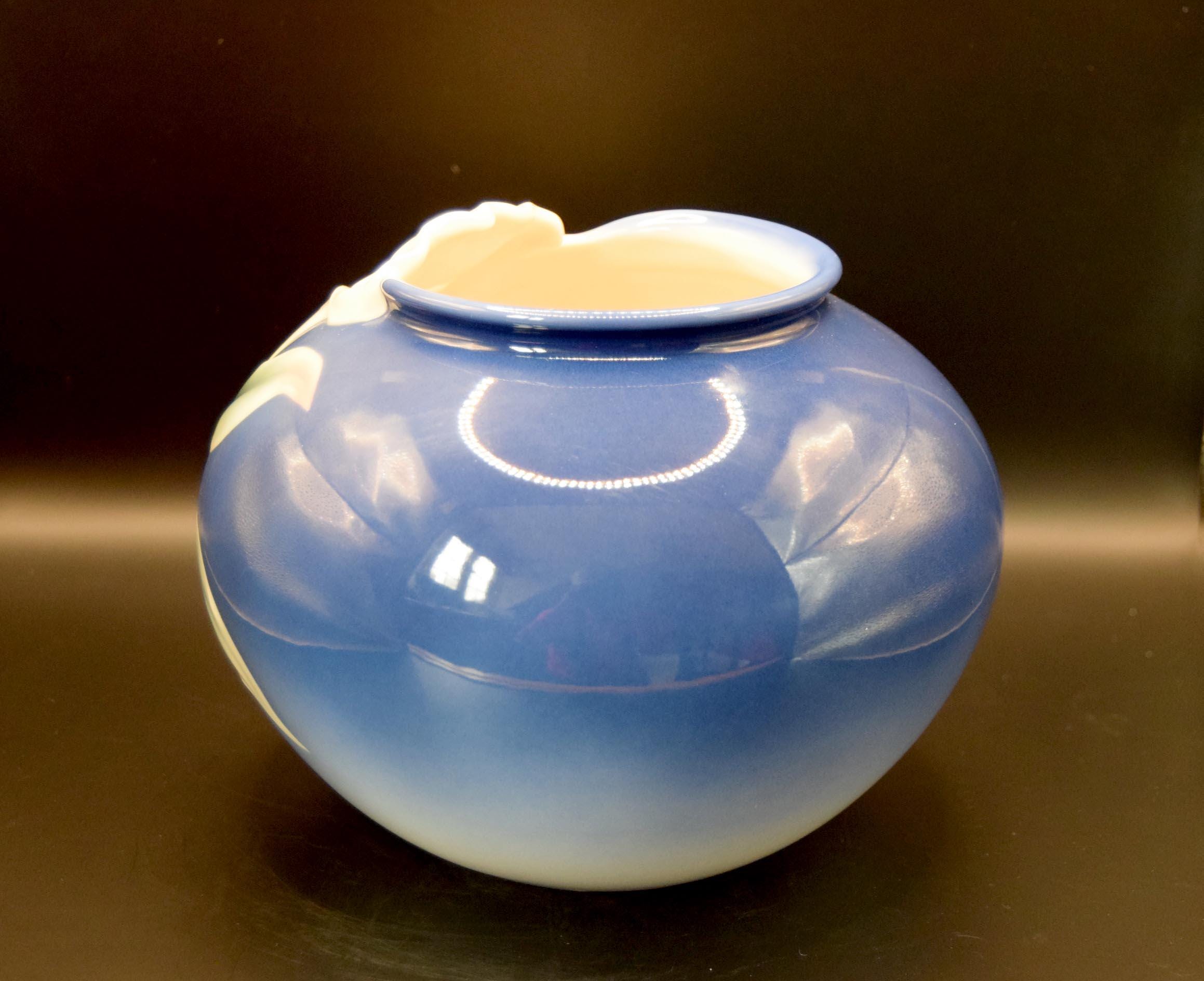 Blue ceramic jar with a white interior on a dark background