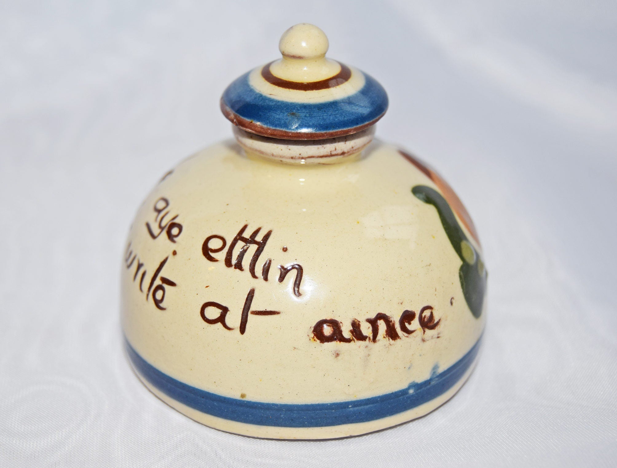 Ceramic jar with blue and brown accents on a white background