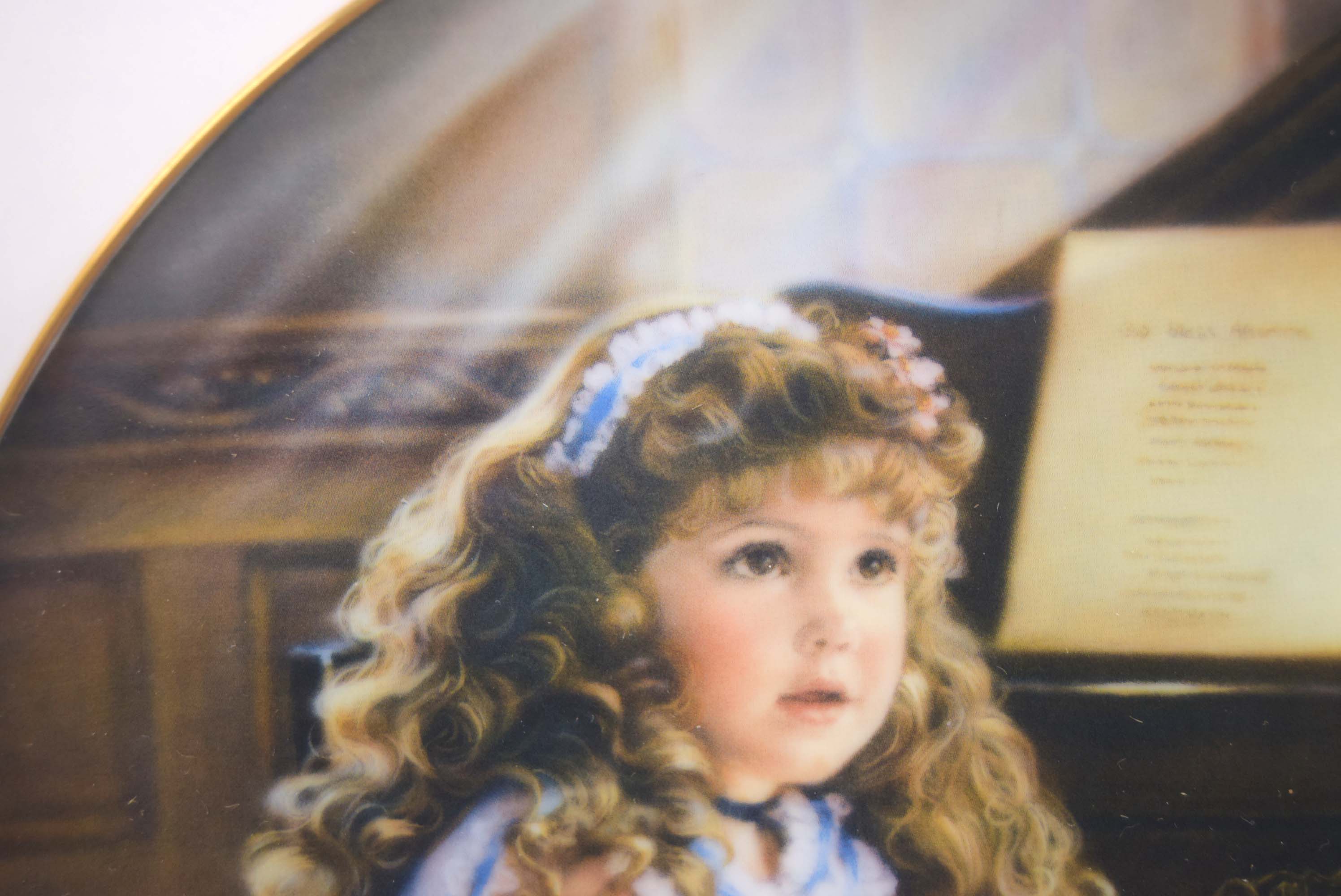 Painting of a young girl with curly hair and a headband, sitting in front of a piano.