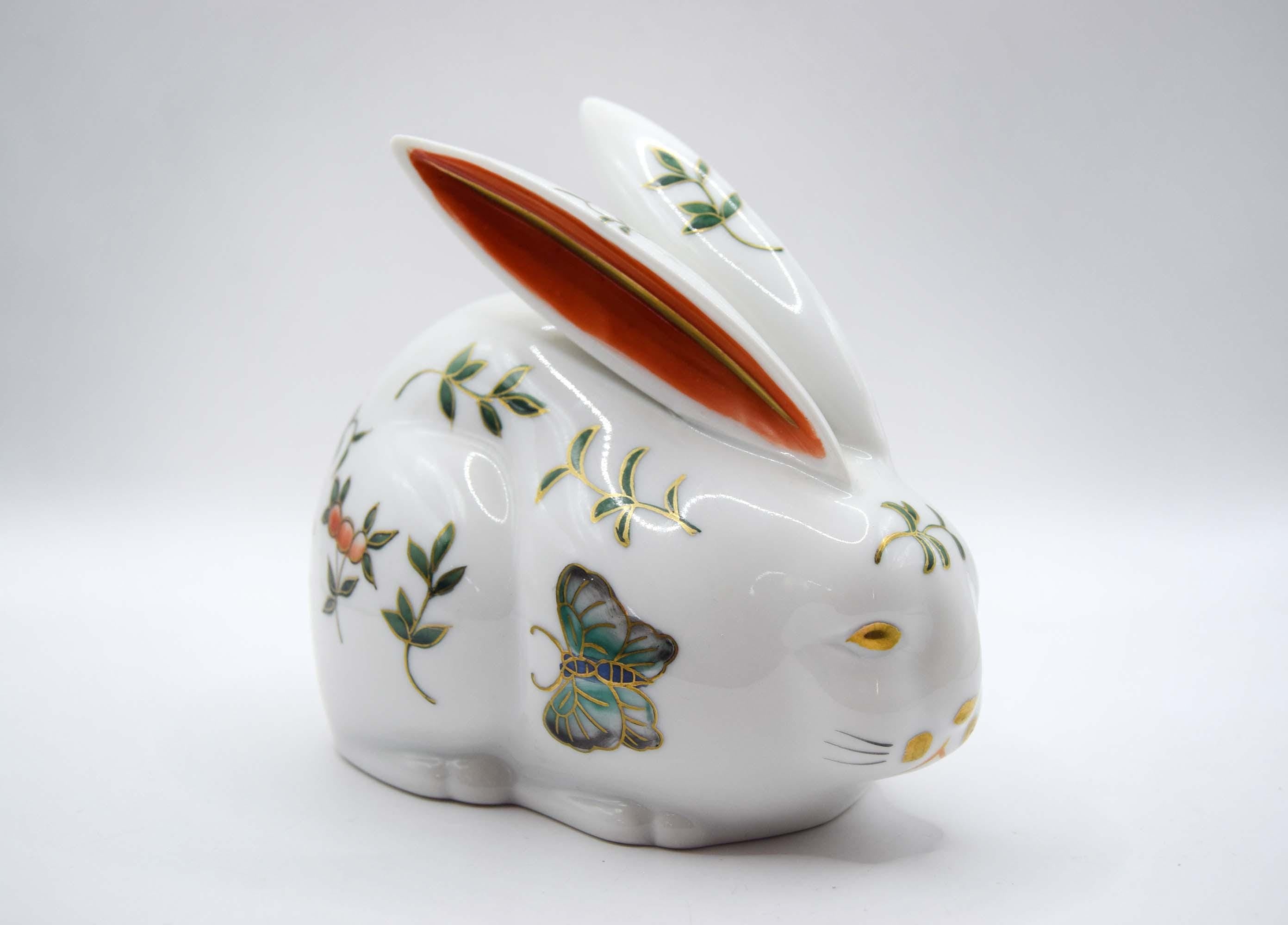 Decorative rabbit-shaped paperweight with floral and butterfly designs on a white background