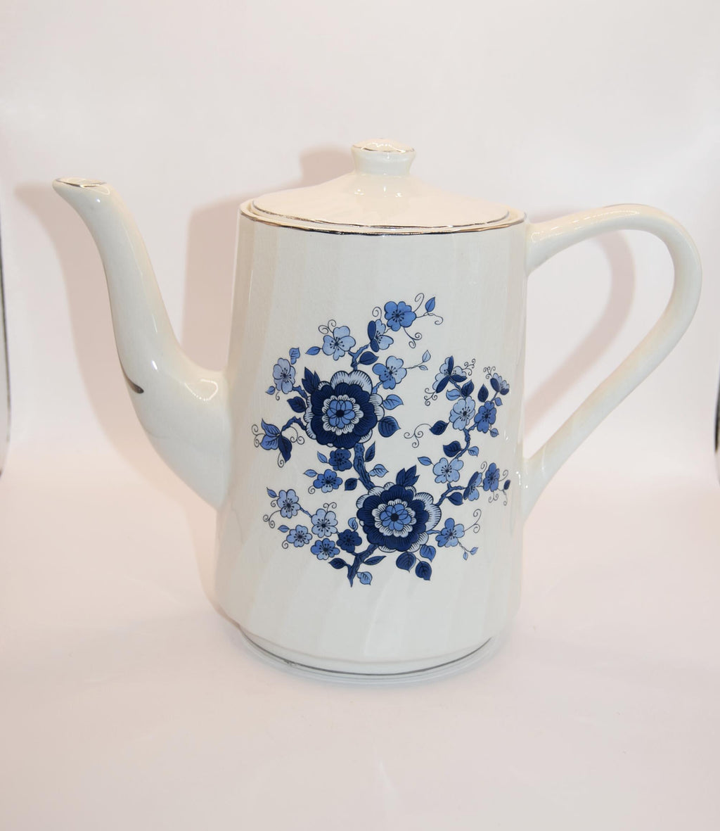 White teapot with blue floral design on a white background