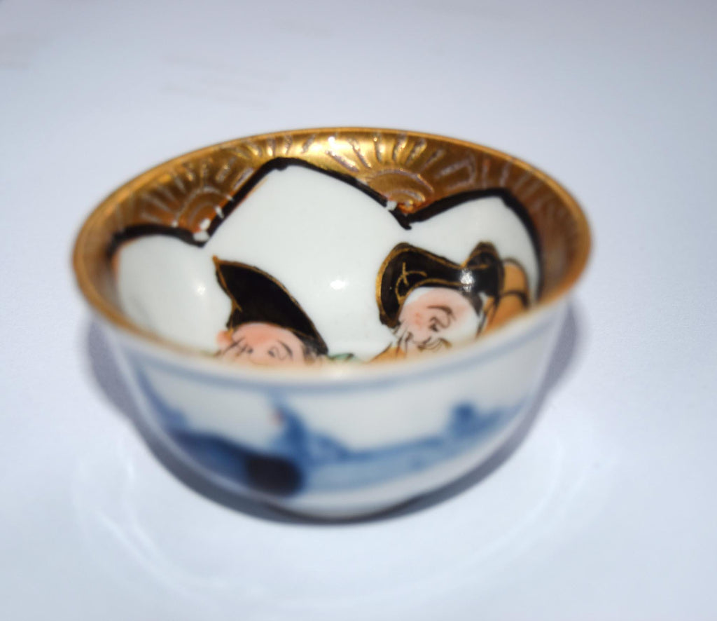 Decorative ceramic bowl with gold rim and painted design on a white background