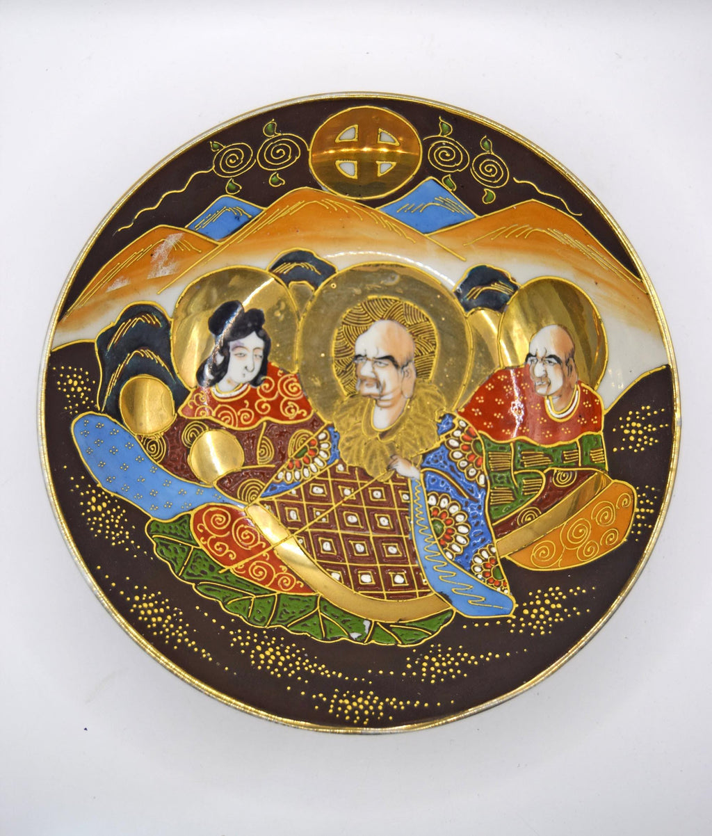 Decorative plate with artistic depiction of three figures on a white background