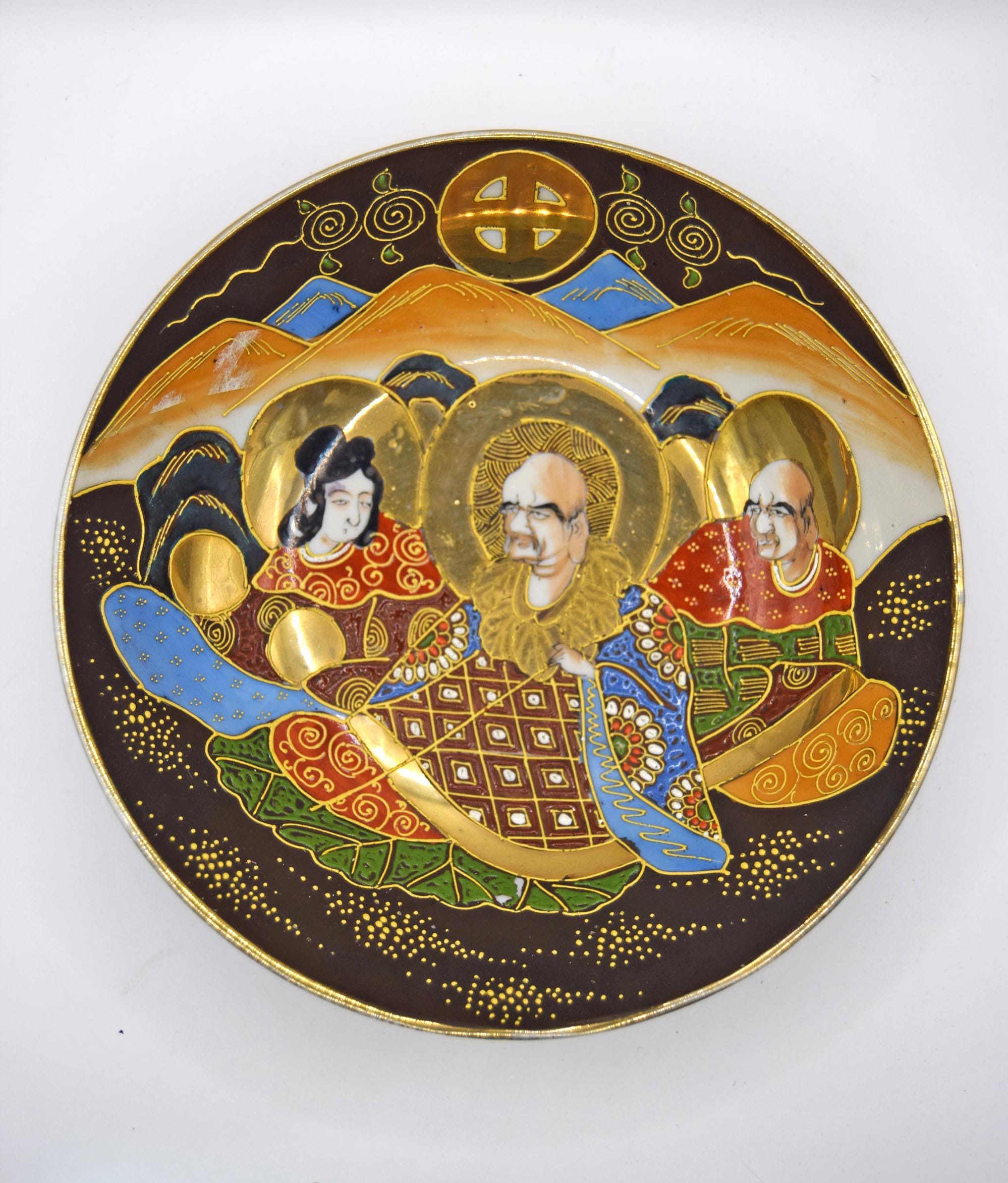 Decorative plate with artistic depiction of three figures on a white background