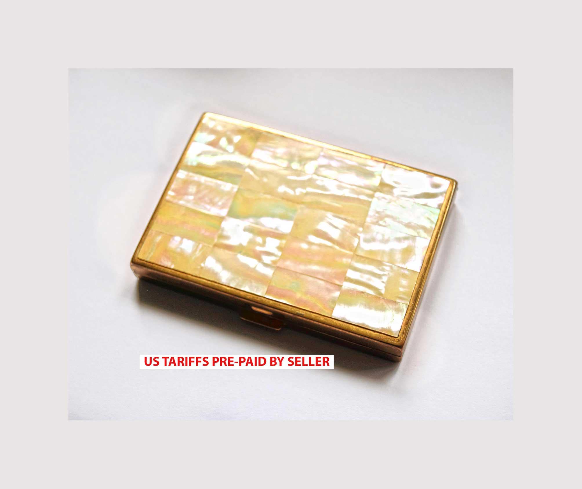 1950s vintage powder compact from AGME Switzerland, featuring a stunning mother-of-pearl lid and golden-tone brass interior.
