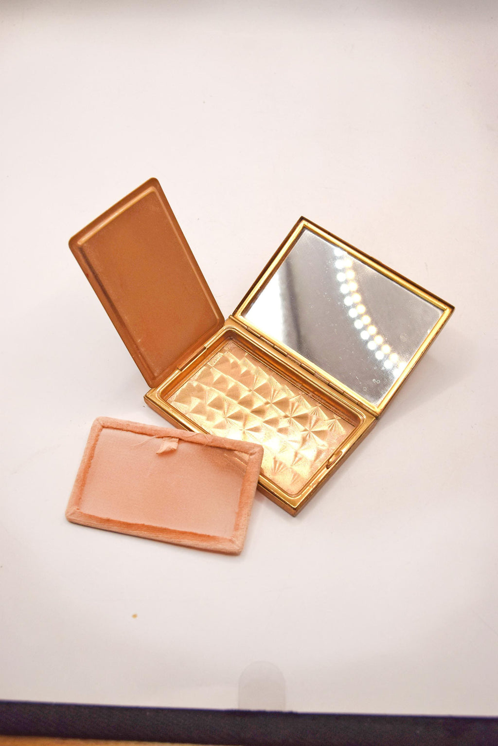 1950s vintage powder compact from AGME Switzerland, featuring a stunning mother-of-pearl lid and golden-tone brass interior.