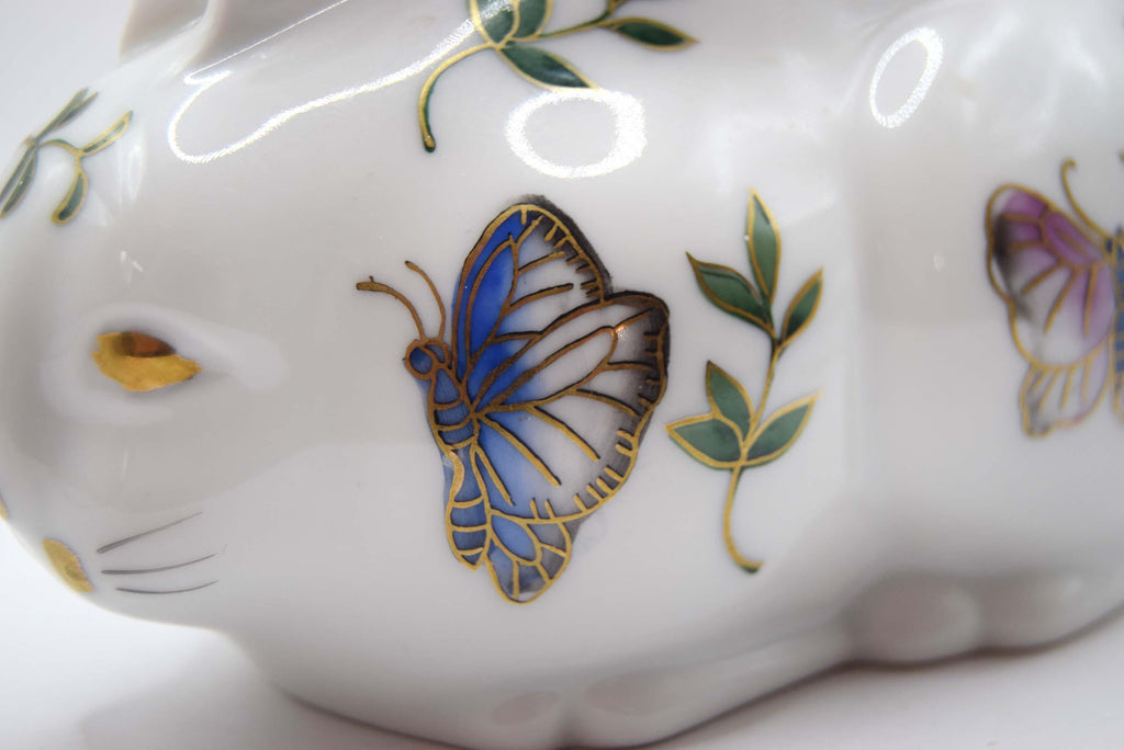 Close-up of a ceramic paperweight with butterfly and floral designs on a white background