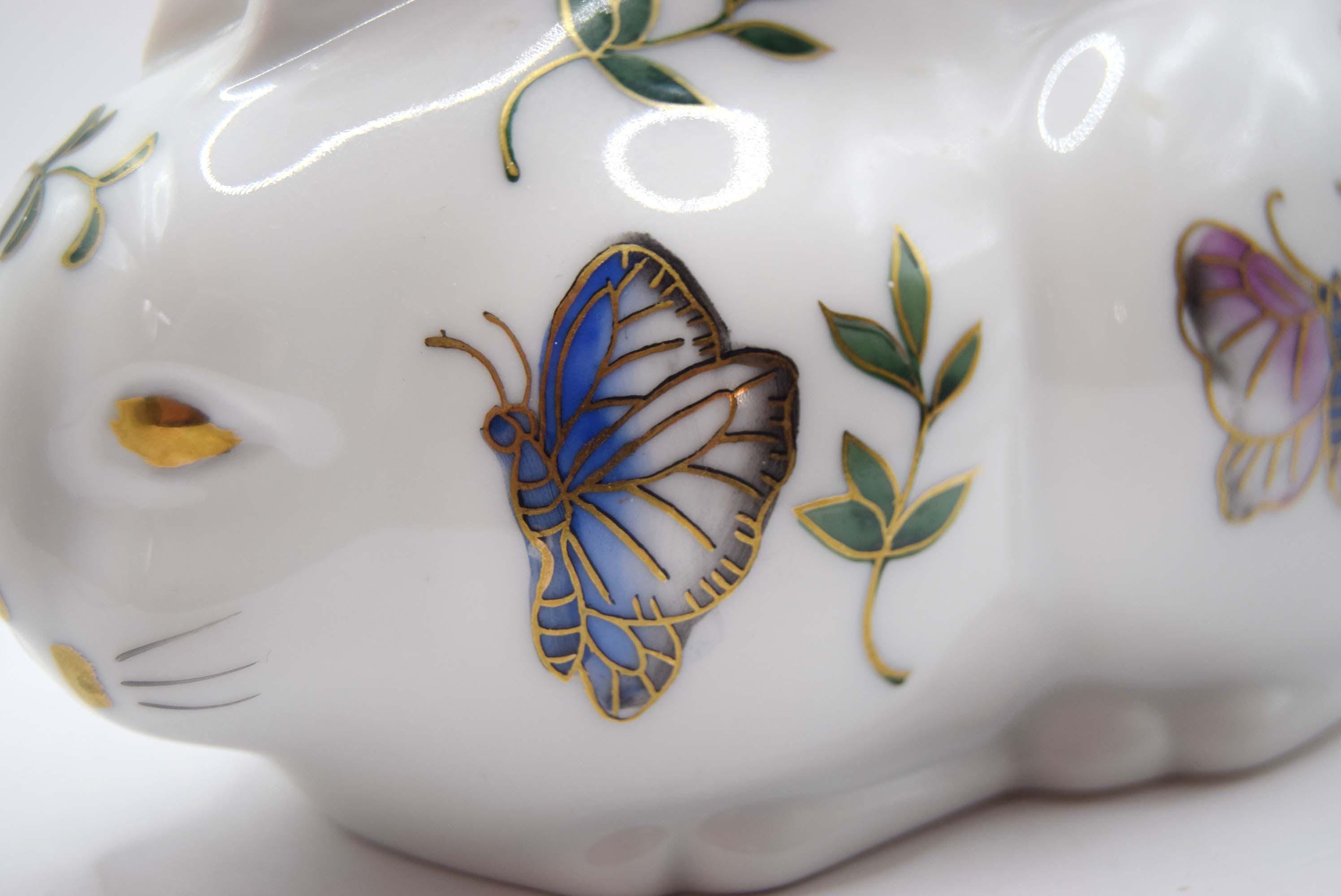 Close-up of a ceramic paperweight with butterfly and floral designs on a white background