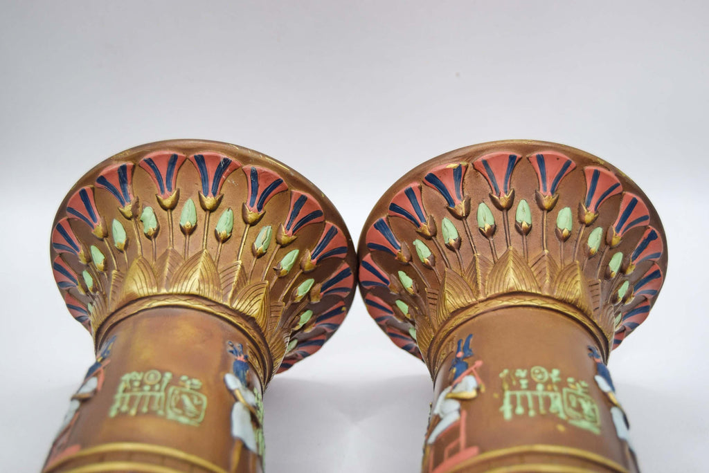 Pair of intricately designed bronze candle holders with decorative patterns on a white background