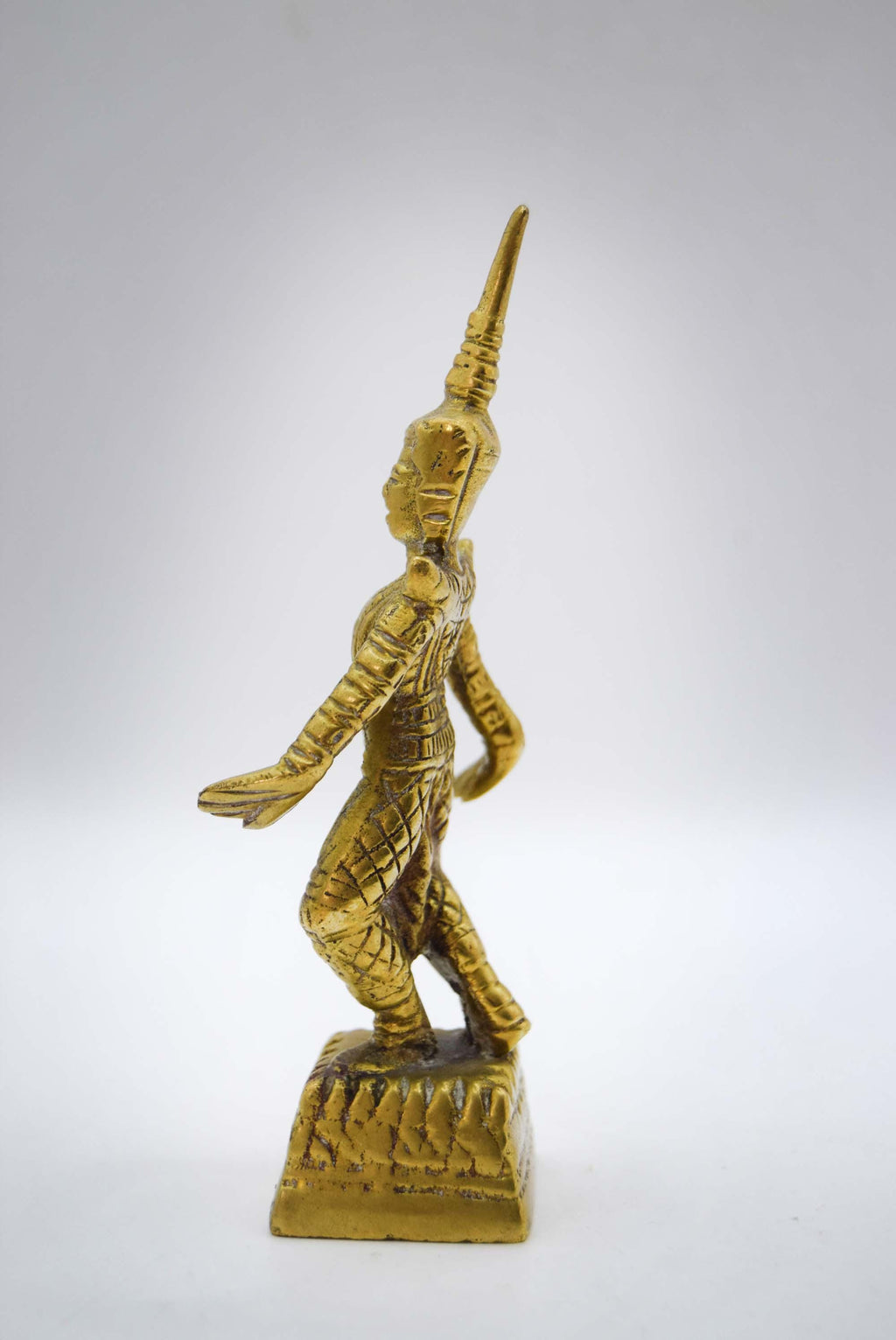 Gold-colored statue of a warrior on a white background