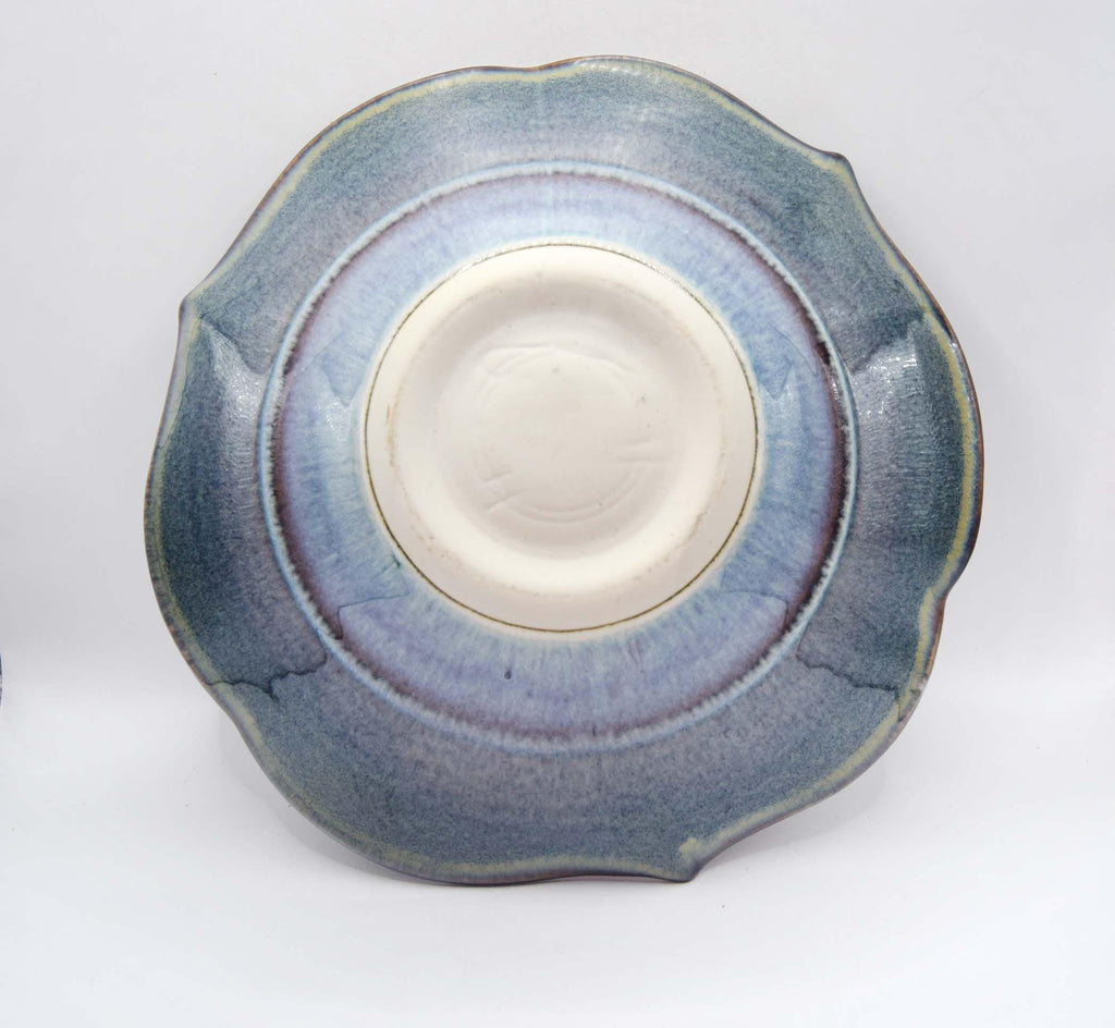 Ceramic plate with blue glaze on a white background
