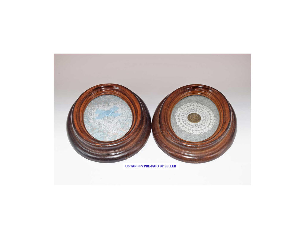 Two round wooden frames with decorative contents on a plain background