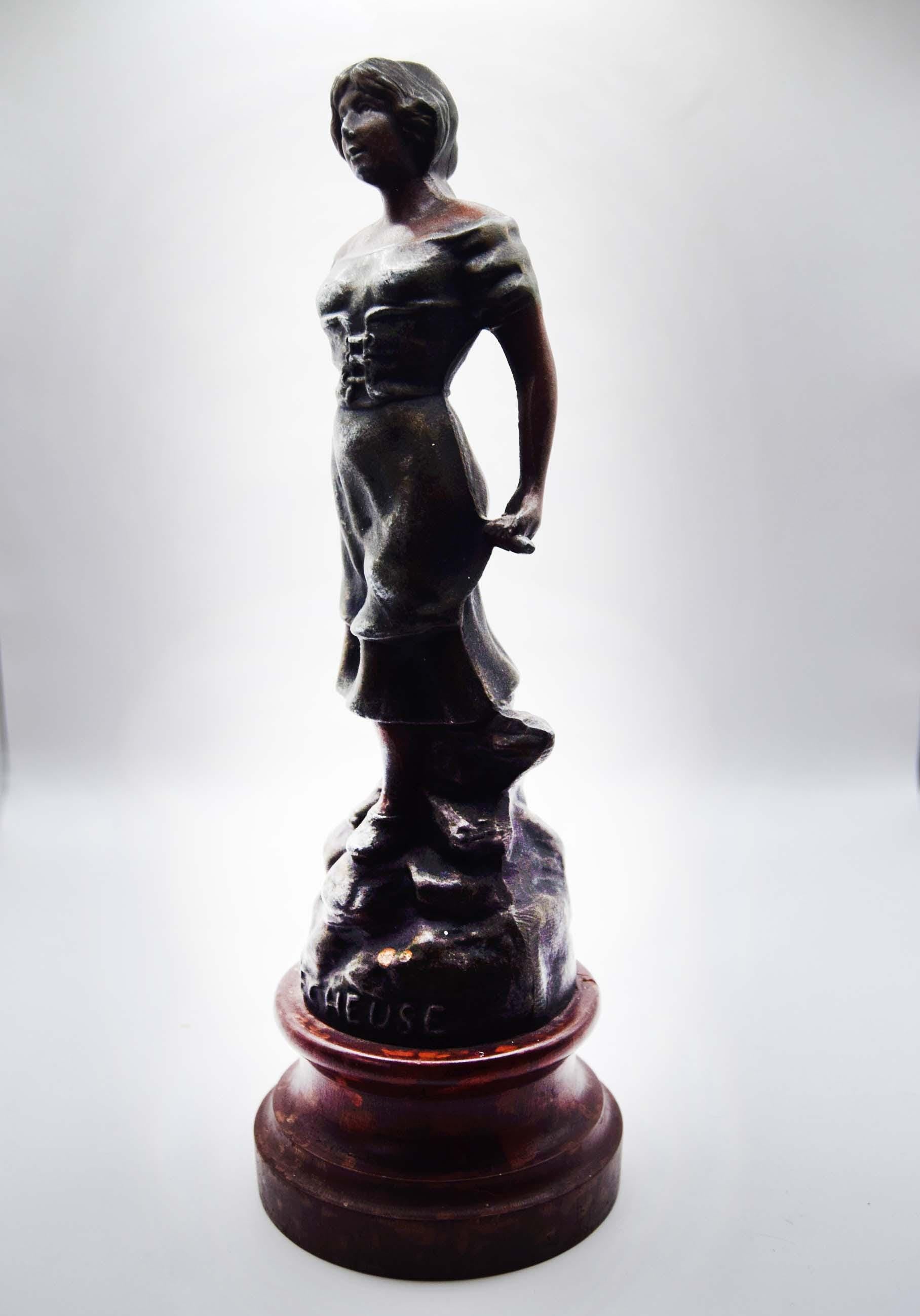 Bronze statue of a figure on a white background