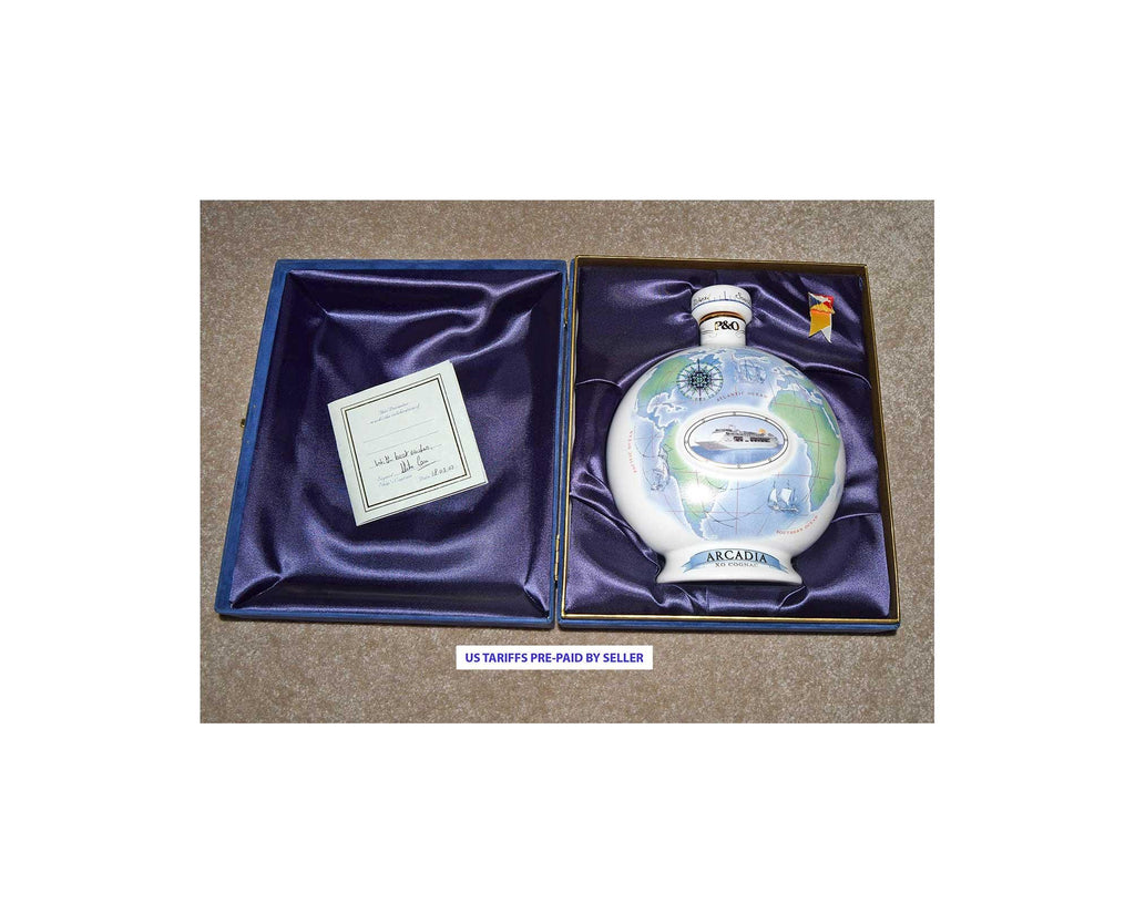 Decorative bottle with a blue and white design in a purple satin case on a beige surface.