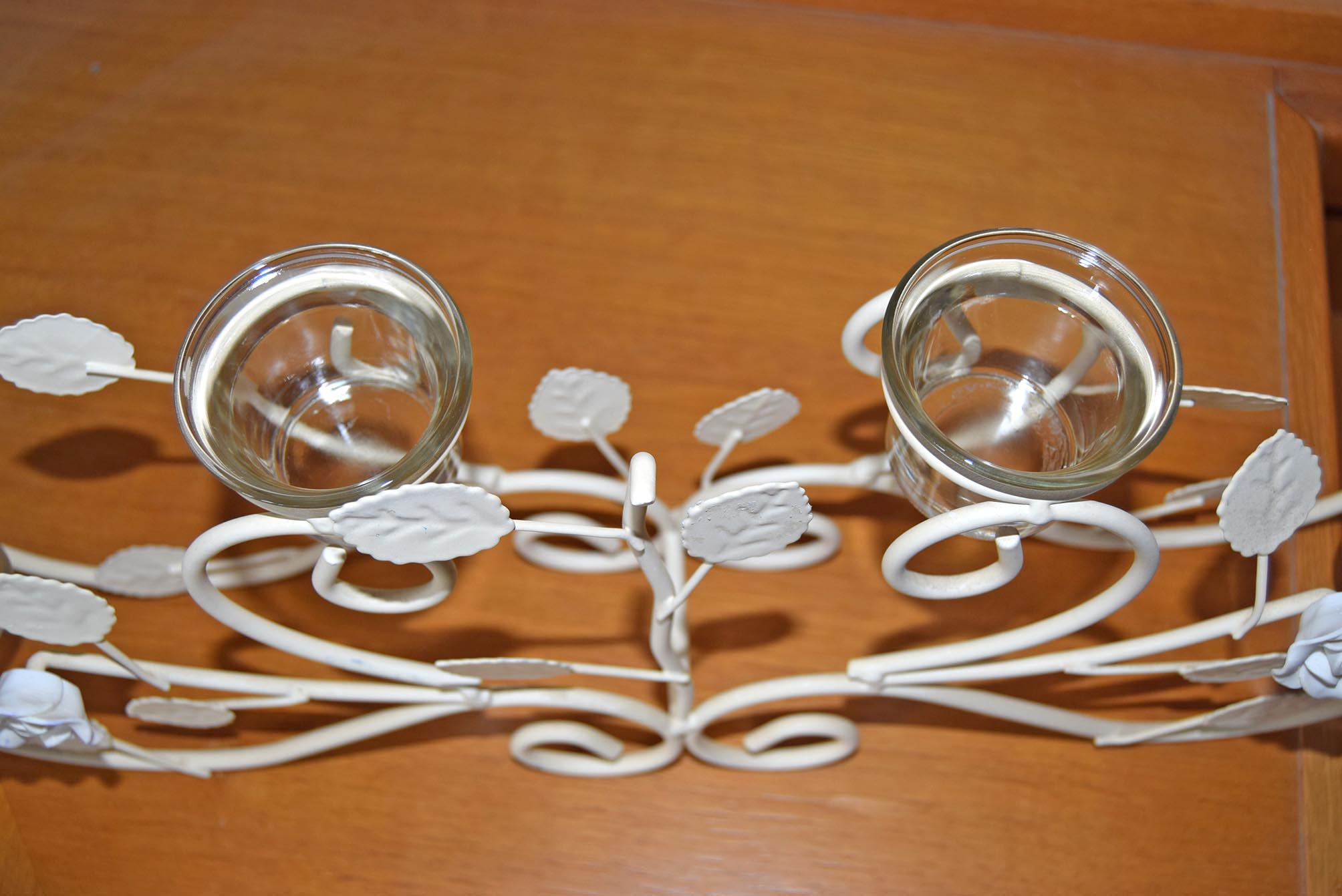 Decorative metal candelabra with two candle holders on a wooden surface