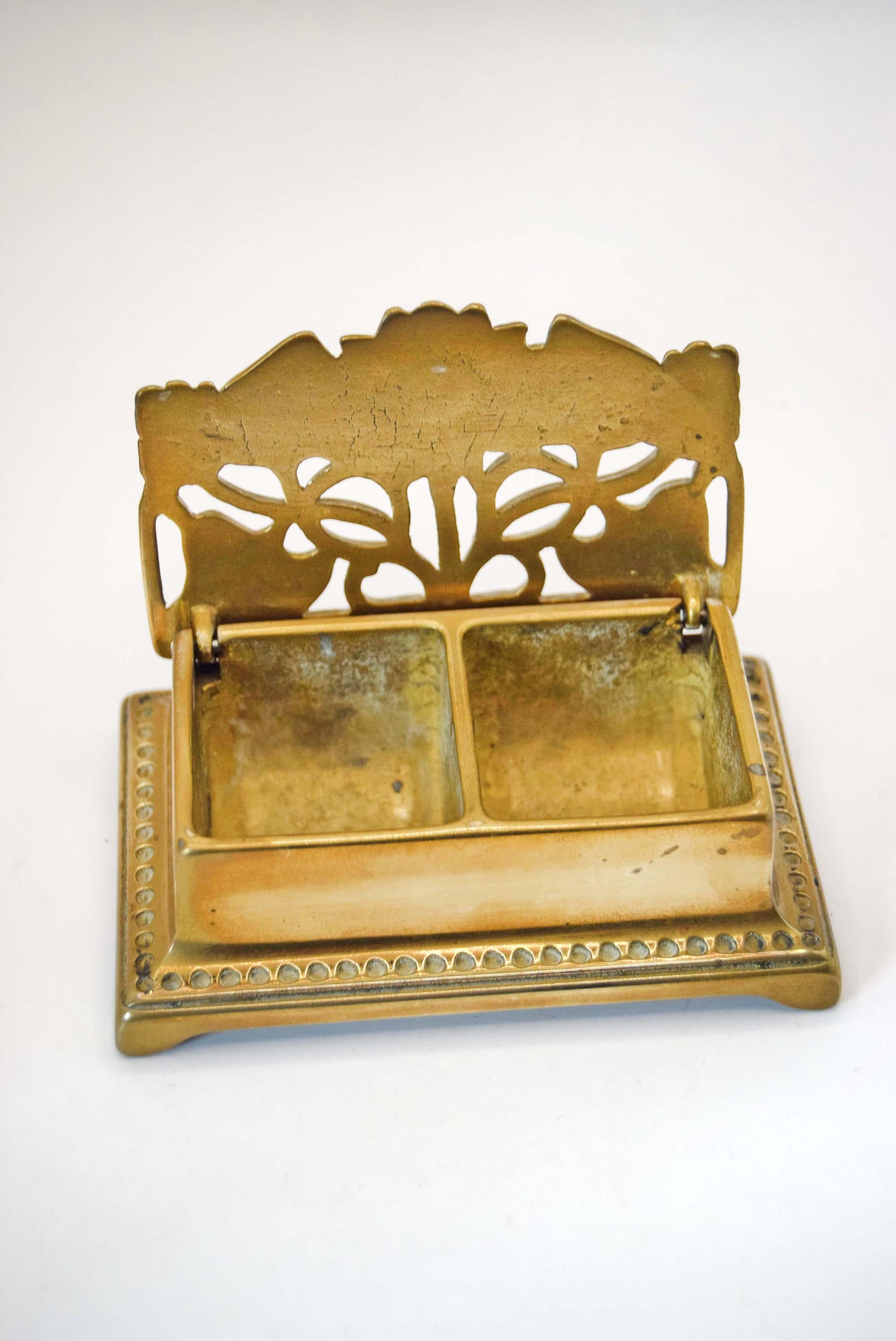 Decorative brass holder with cut-out design on a white background