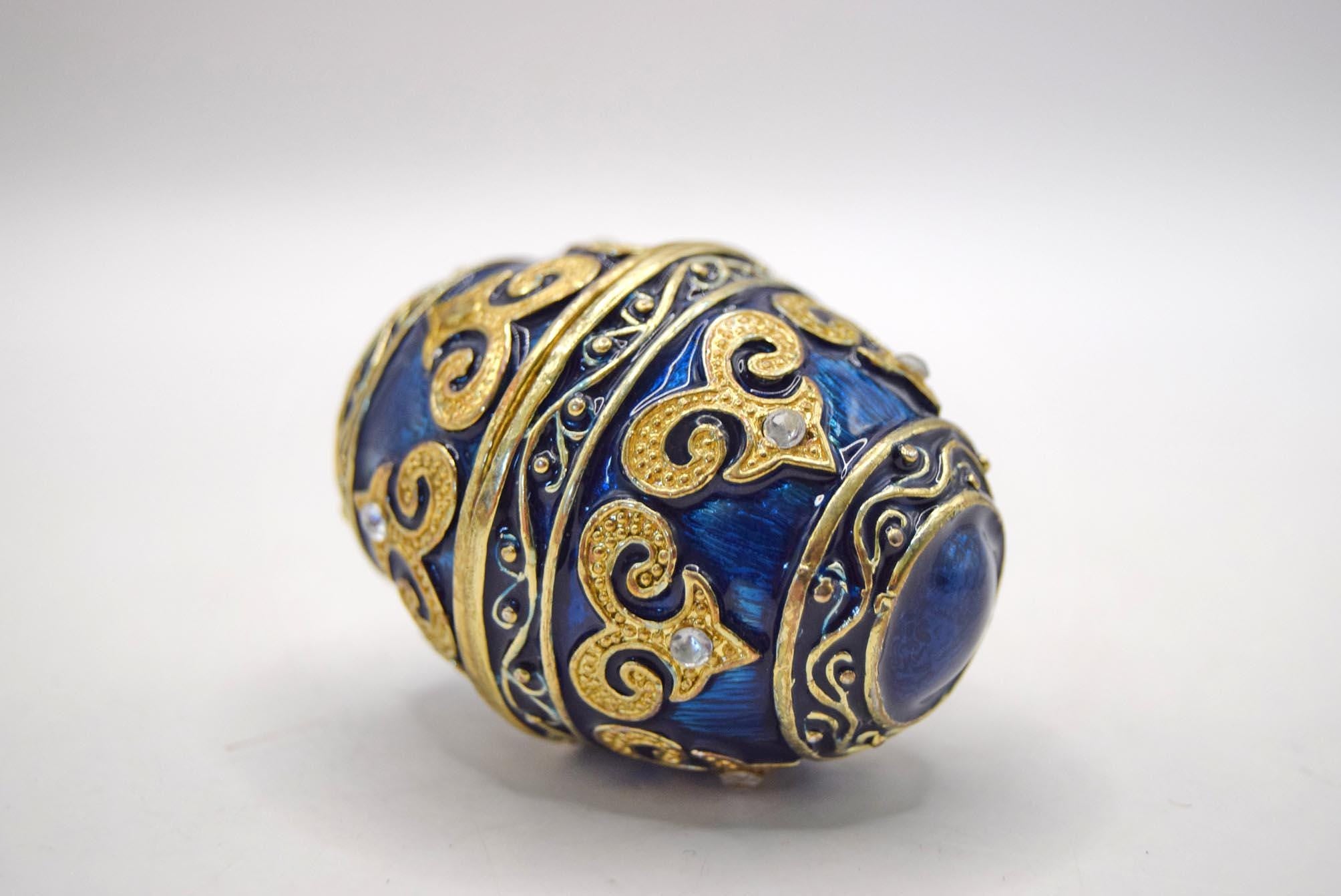 Decorative blue and gold egg-shaped object on a white background