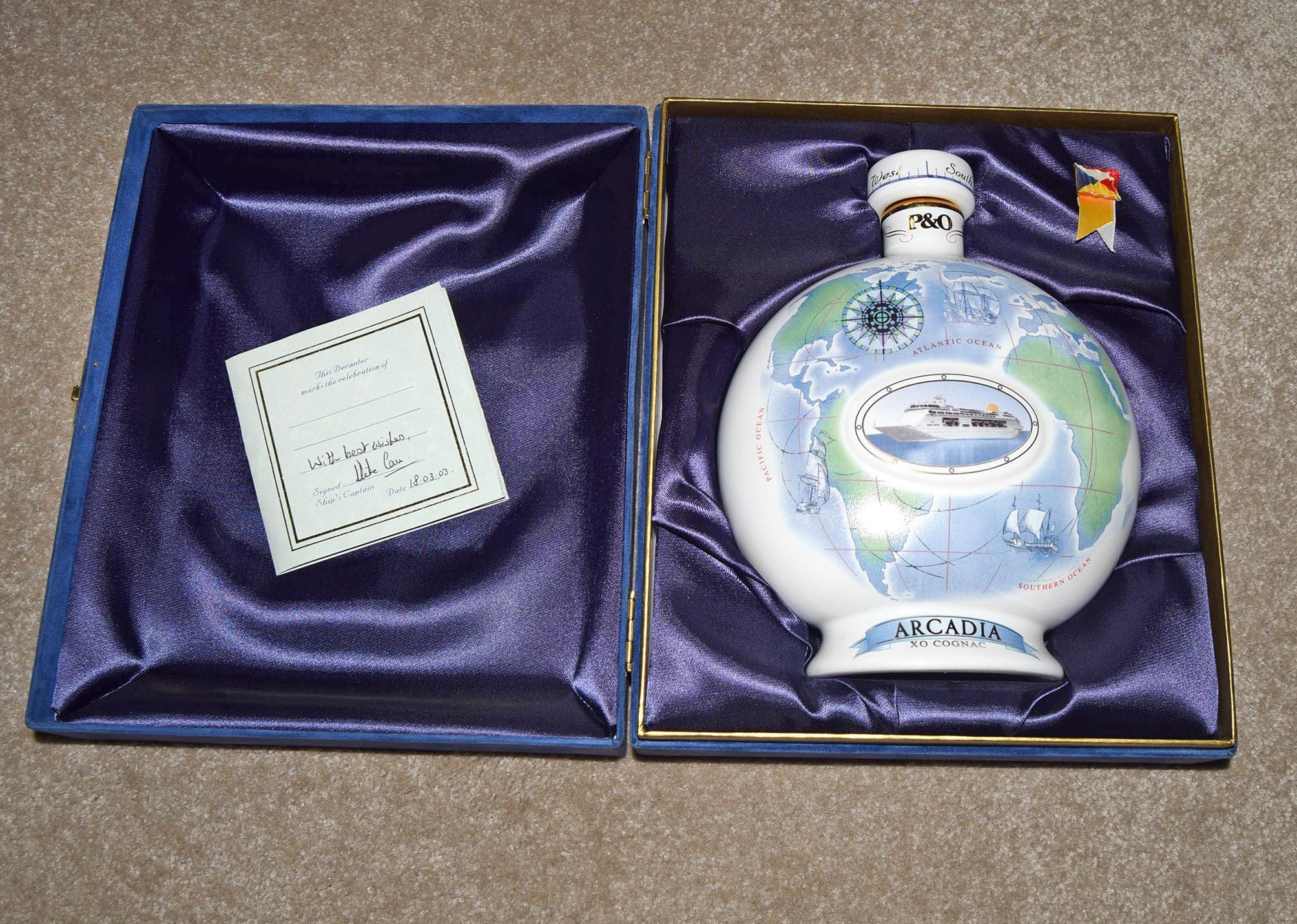 Decorative bottle with 'Arcadia' branding in a blue satin-lined box.
