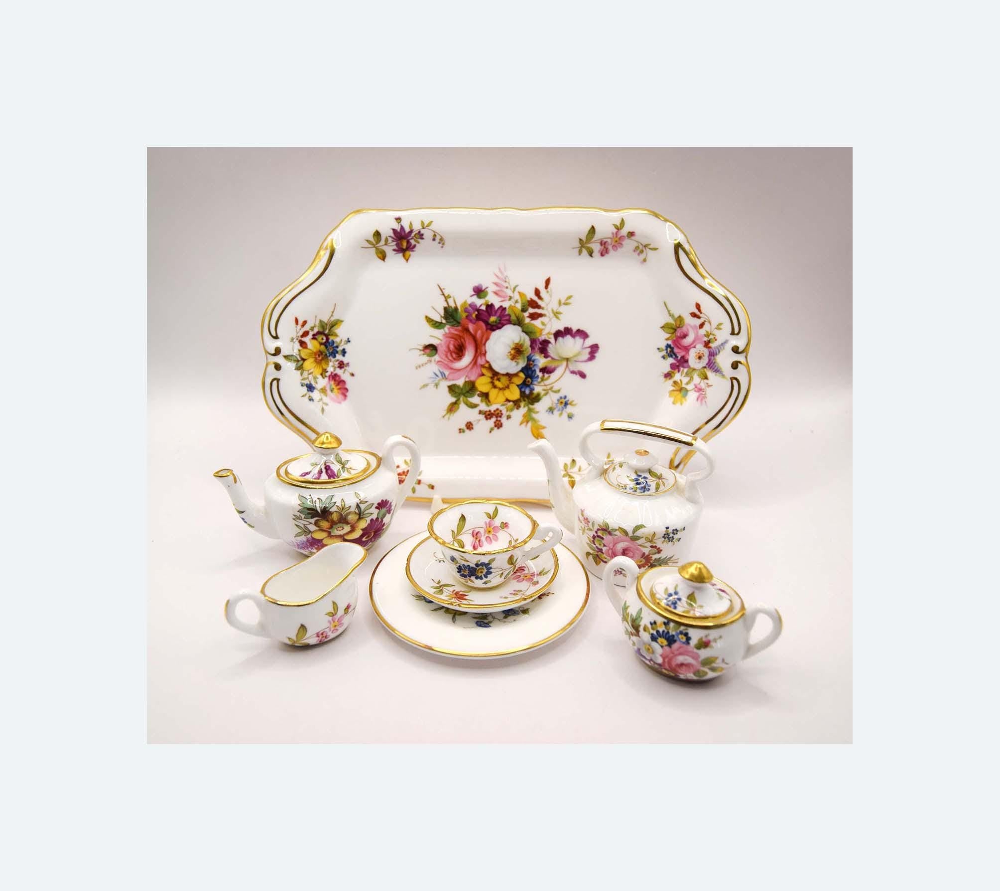  porcelain tea set with floral designs on a plain background